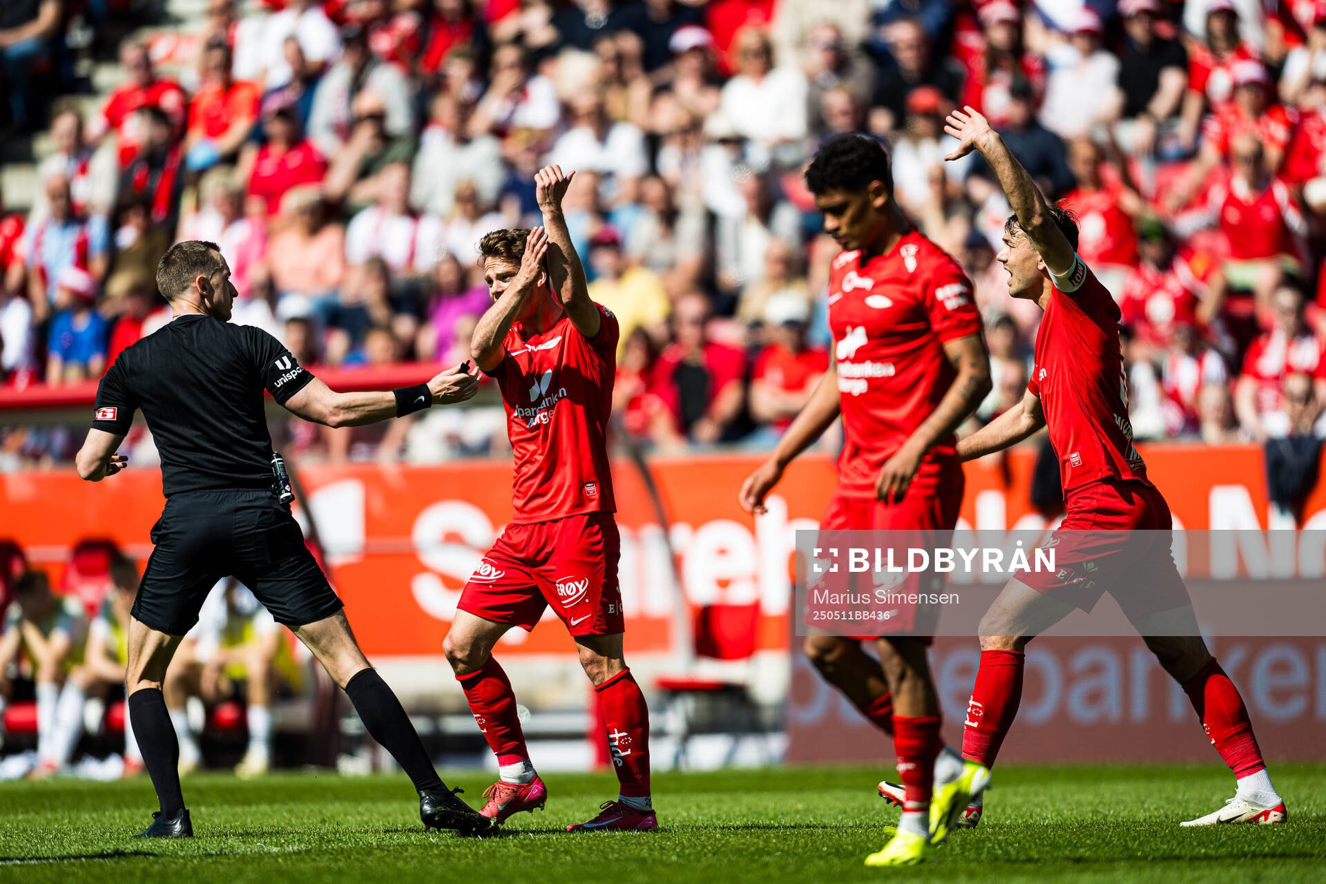 Marius Hansen Grøtta, referee, Felix Horn Myhre and Fredrik Pallesen Knudsen of Brann who reacts during the Eliteserien match between Brann and Rosenborg on May 11, 2025 in Bergen.