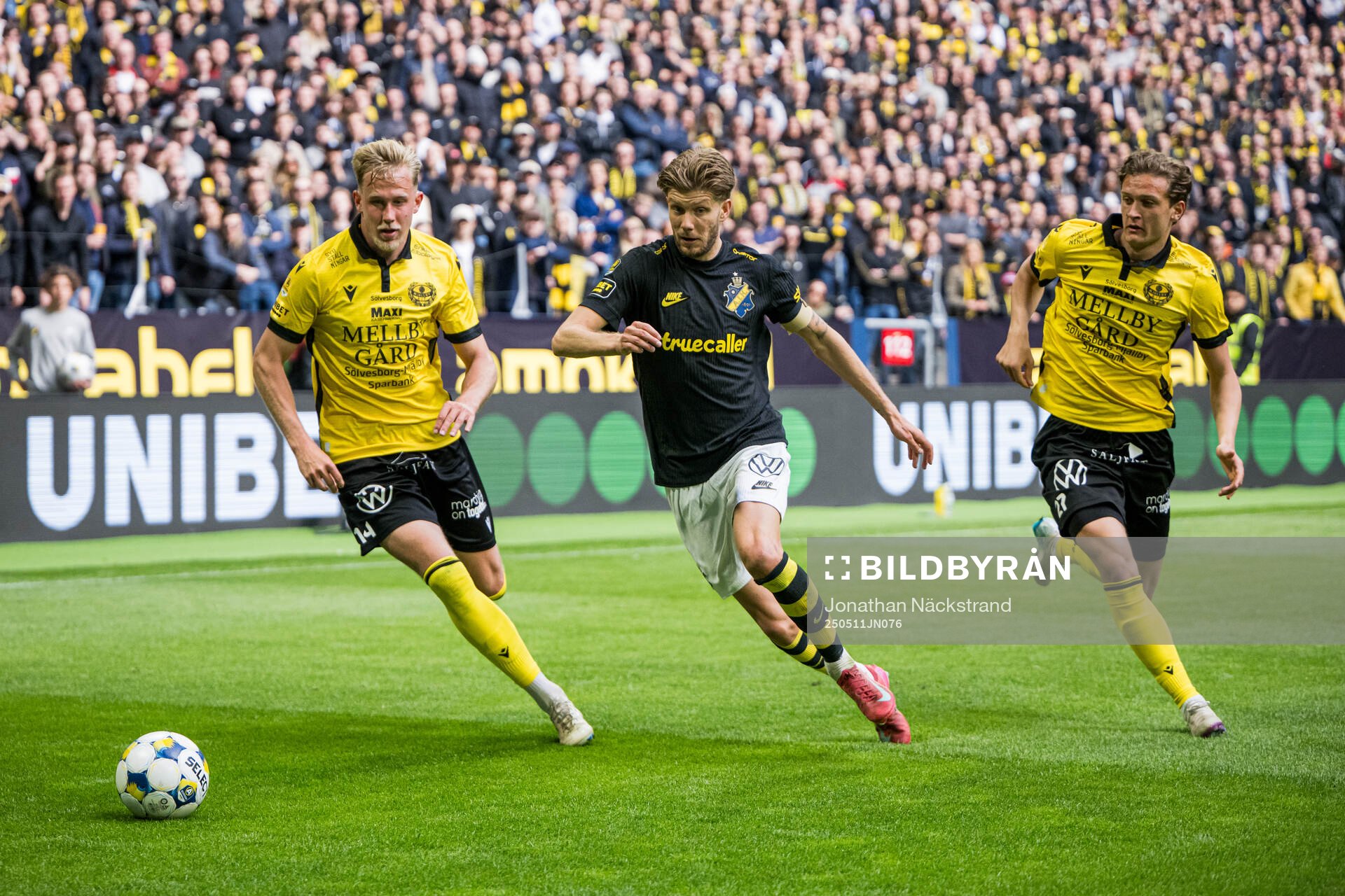 Mjällbys Herman Johansson och Ludvig Tidstrand mot AIKs Anton Salétros under fotbollsmatchen i Allsvenskan mellan AIK och Mjällby den 11 maj 2025 i Stockholm.