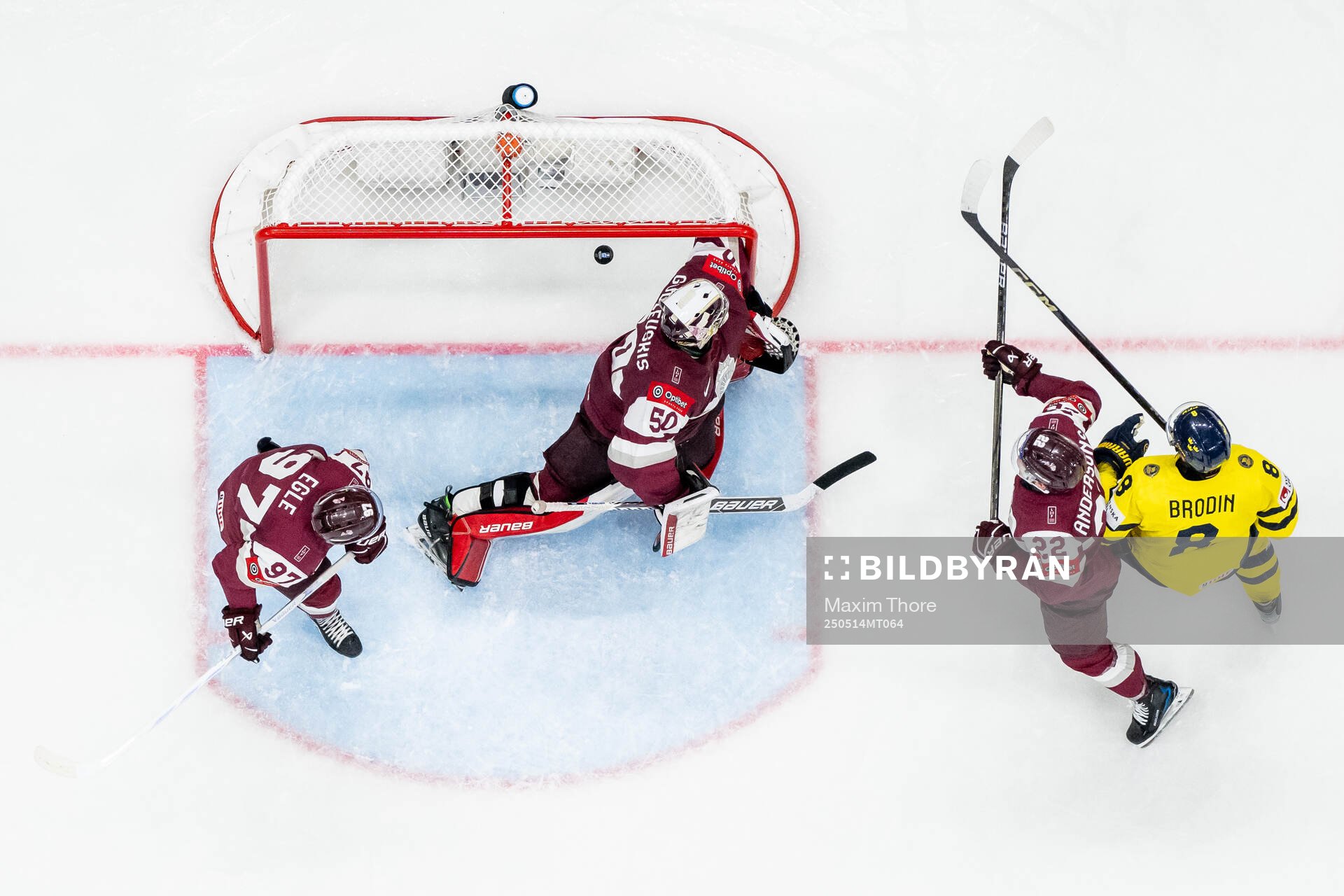 Jonas Brodin of Sweden and Haralds Egle, goalkeeper