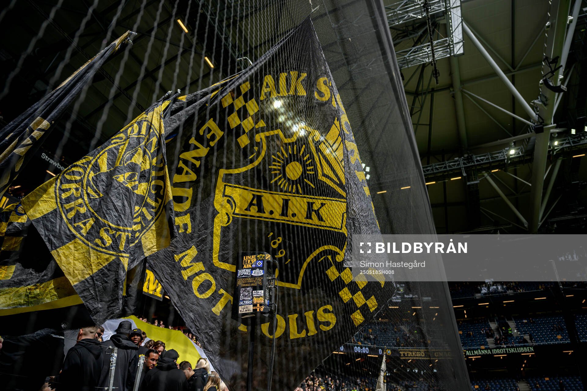 AIKs supportrar med flaggor bakom ett skyddsnät