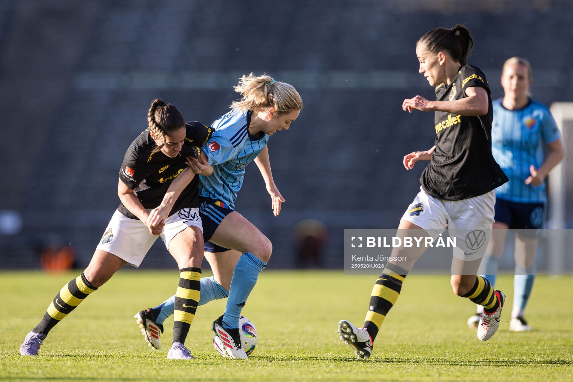 AIKs Daniella Famili och Anna Oskarsson mot Djurgårdens Mimmi Larsson under fotbollsmatchen i Damallsvenskan mellan Djurgården och AIK den 20 maj 2025 i Stockholm.