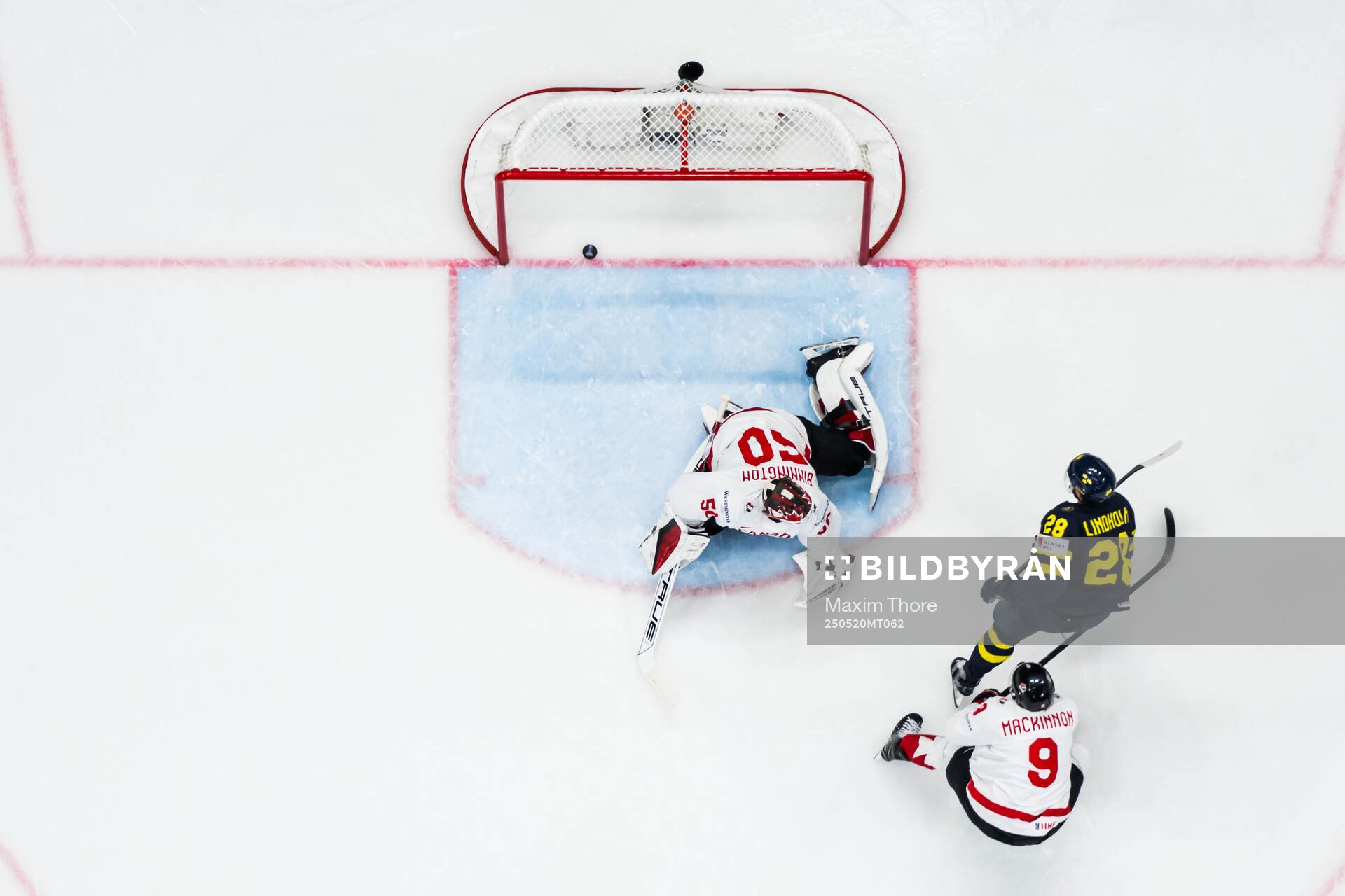 Elias Lindholm of Sweden scores 1-1 behind goaltender
