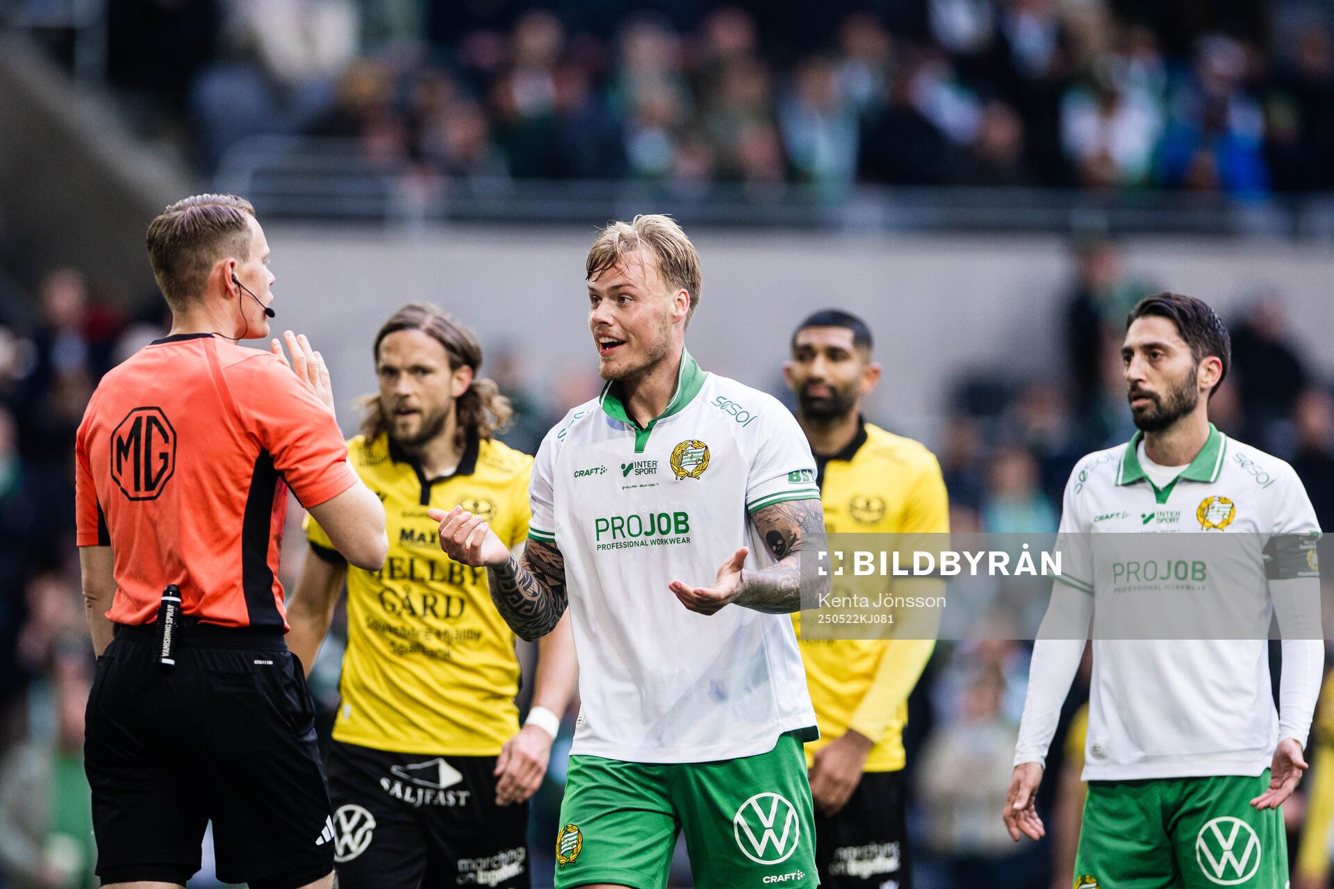 Hammarbys Victor Eriksson och Nahir Besara med domare Oscar Johnson under fotbollsmatchen i Allsvenskan mellan Hammarby och Mjällby den 22 maj 2025 i Stockholm.