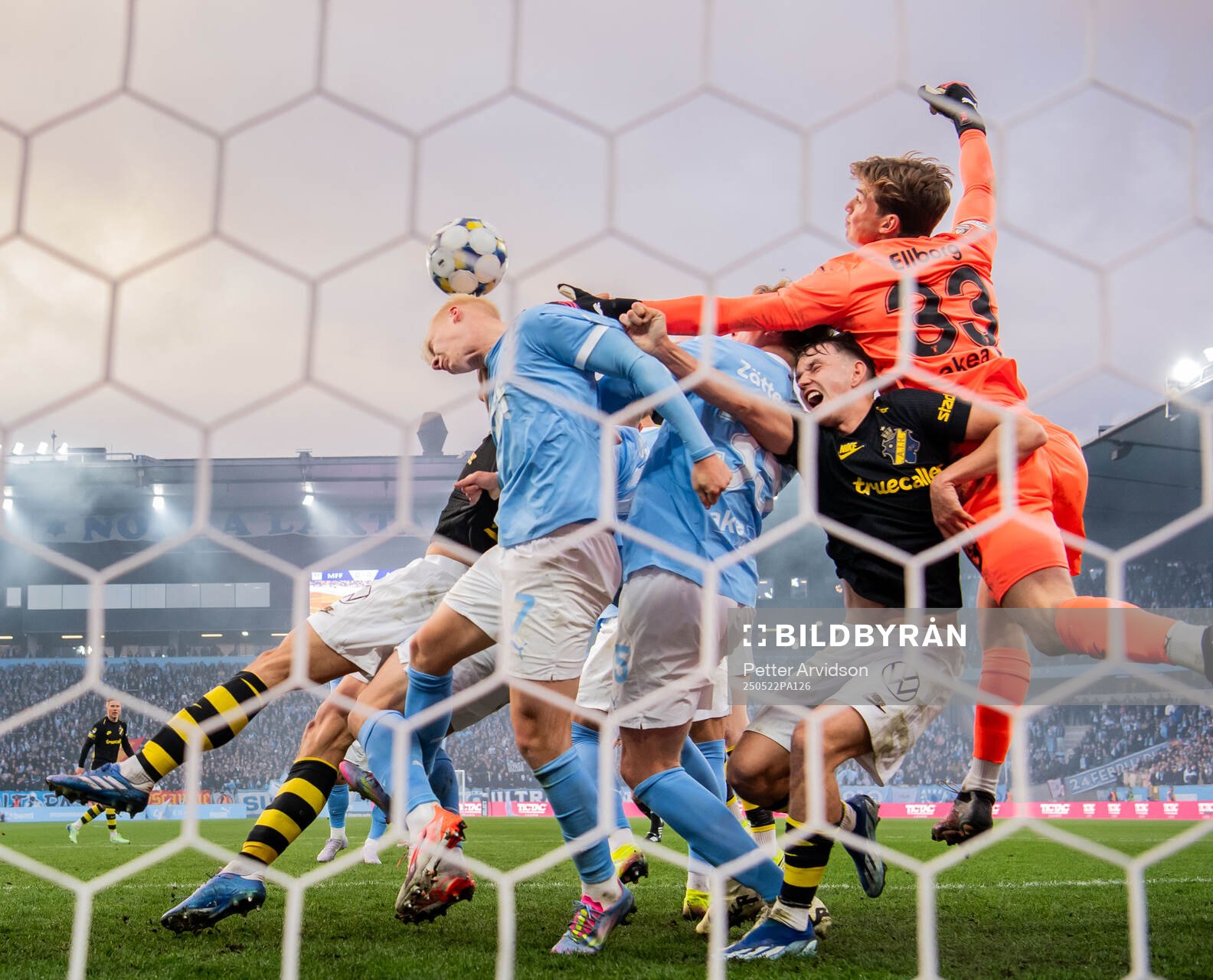 AIKs Kazper Karlsson i kamp med Malmö FFs Daniel Gudjohnsen och målvakt Melker Ellborg under fotbollsmatchen i Allsvenskan mellan Malmö FF och AIK den 22 maj 2025 i Malmö.