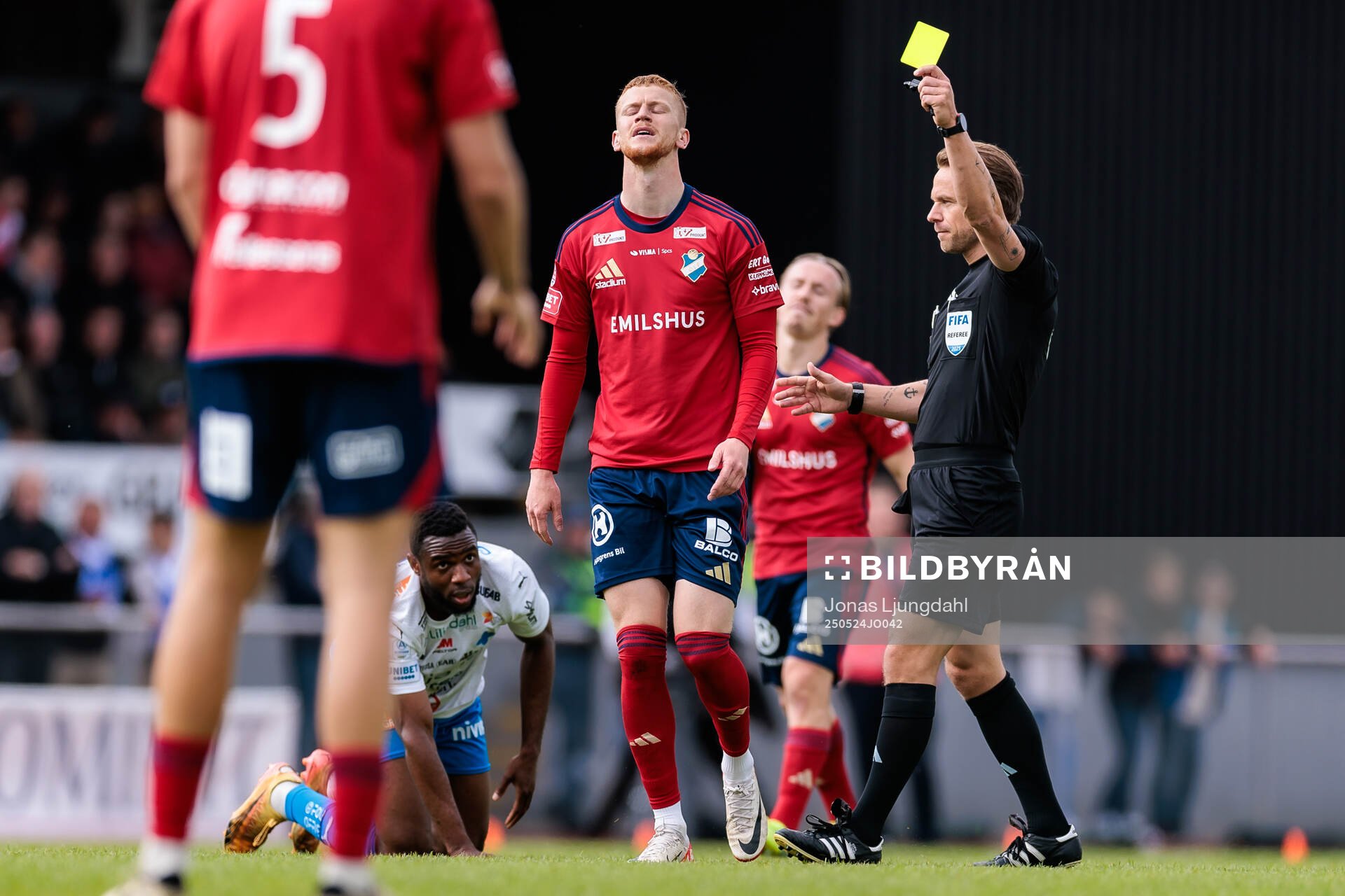 Domare Kristoffer Karlsson delar ut ett gult kort till