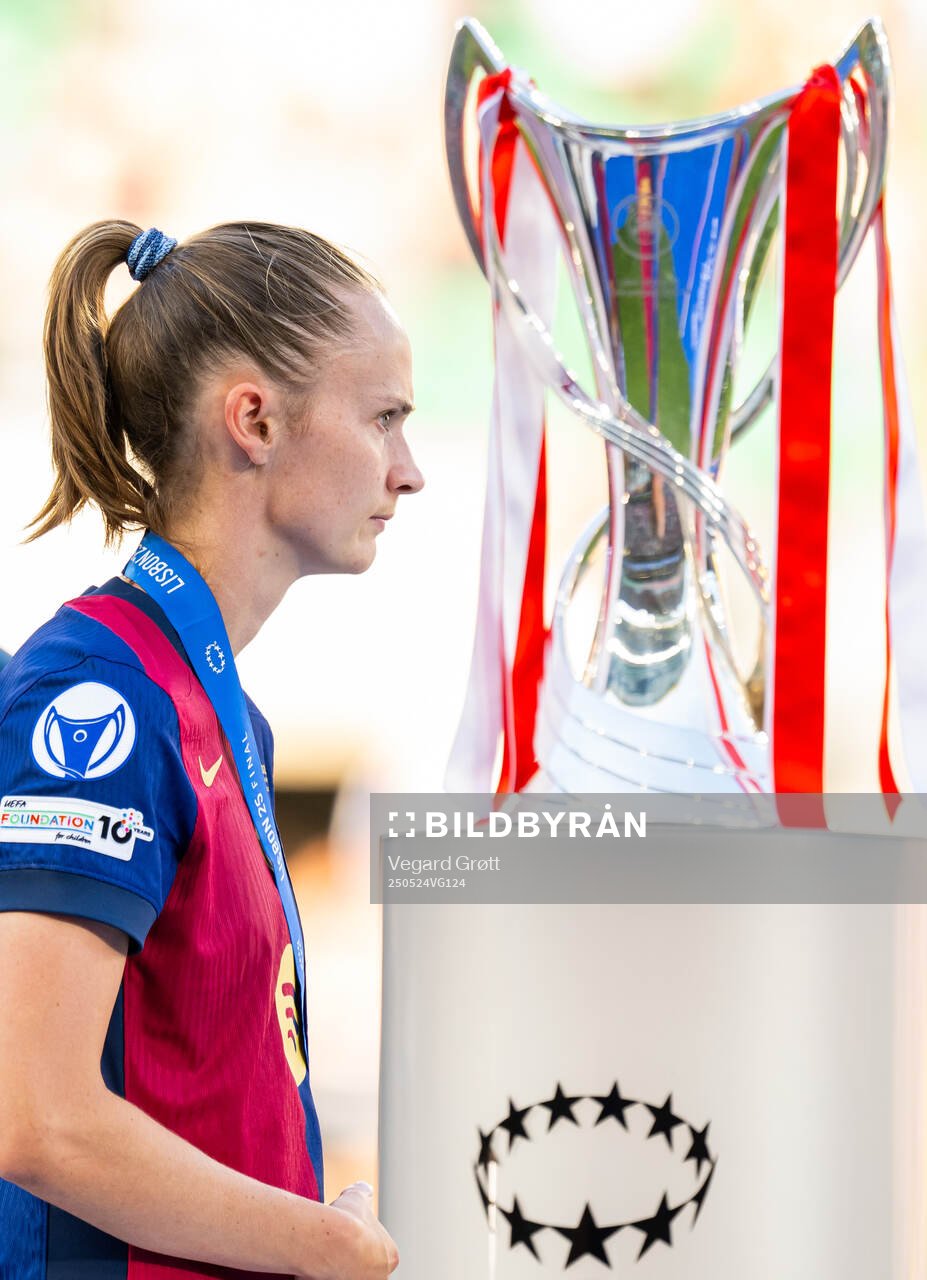Caroline Graham Hansen of Barcelona walks past the trophy