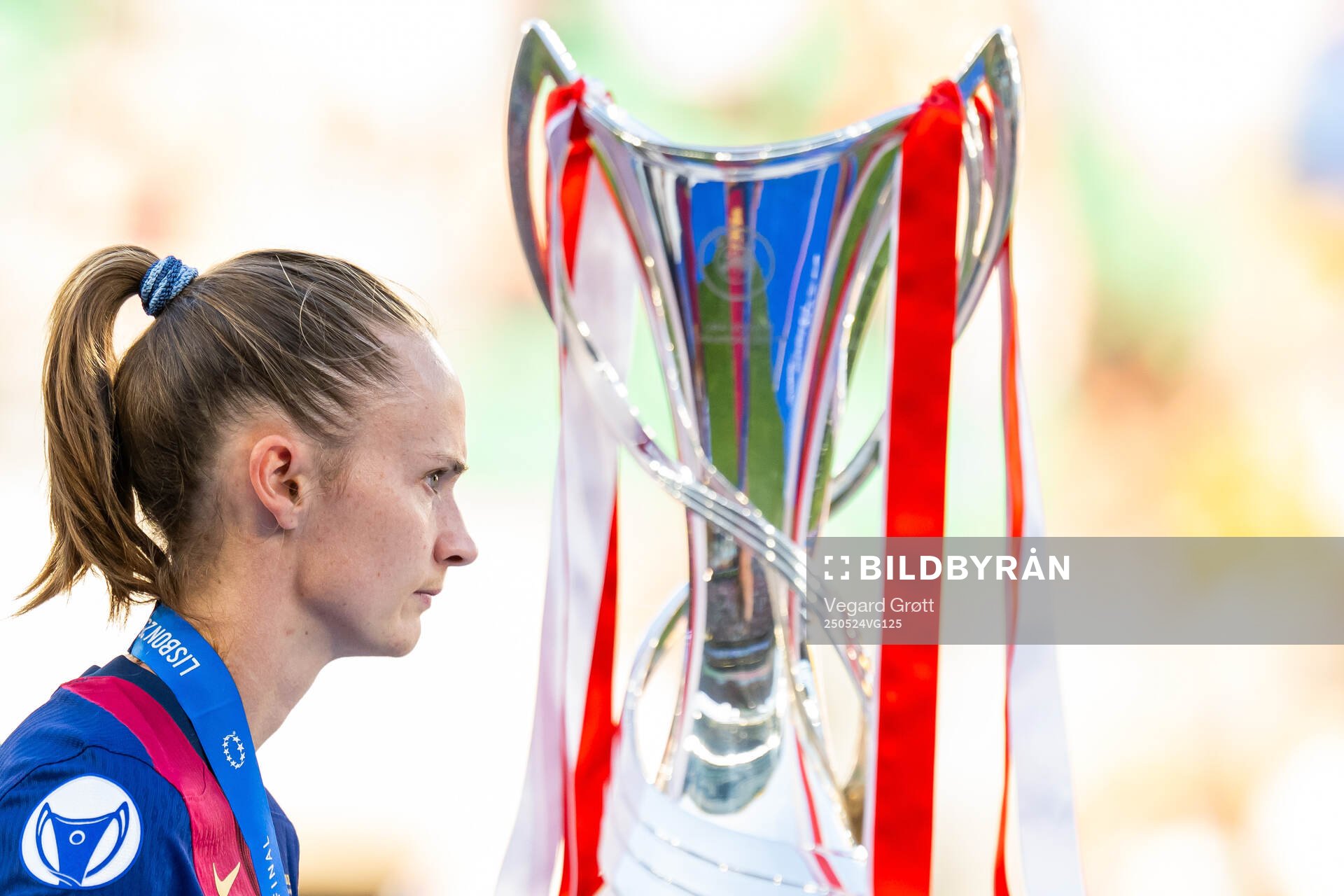 Caroline Graham Hansen of Barcelona walks past the trophy