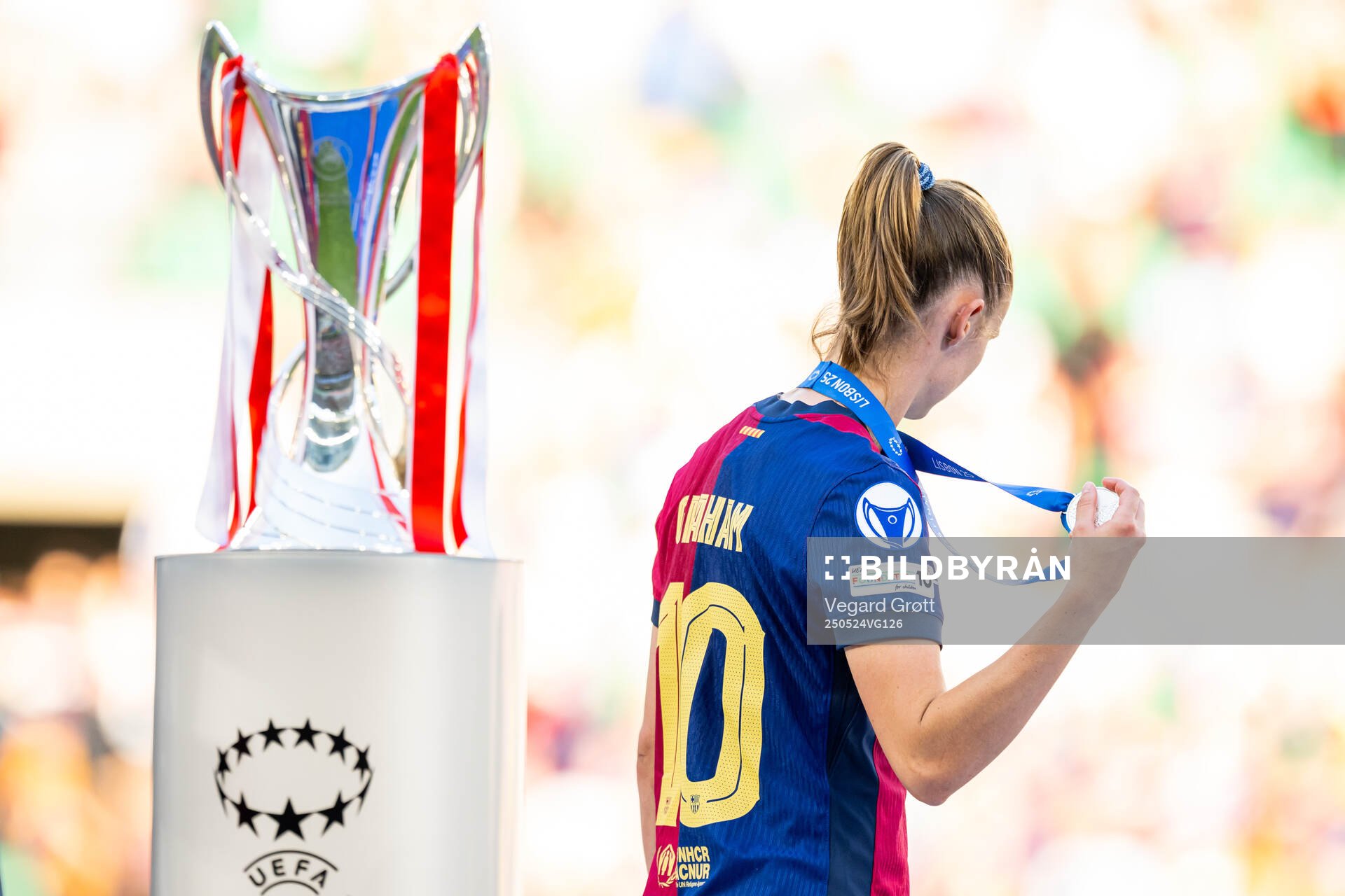 Caroline Graham Hansen of Barcelona walks past the trophy