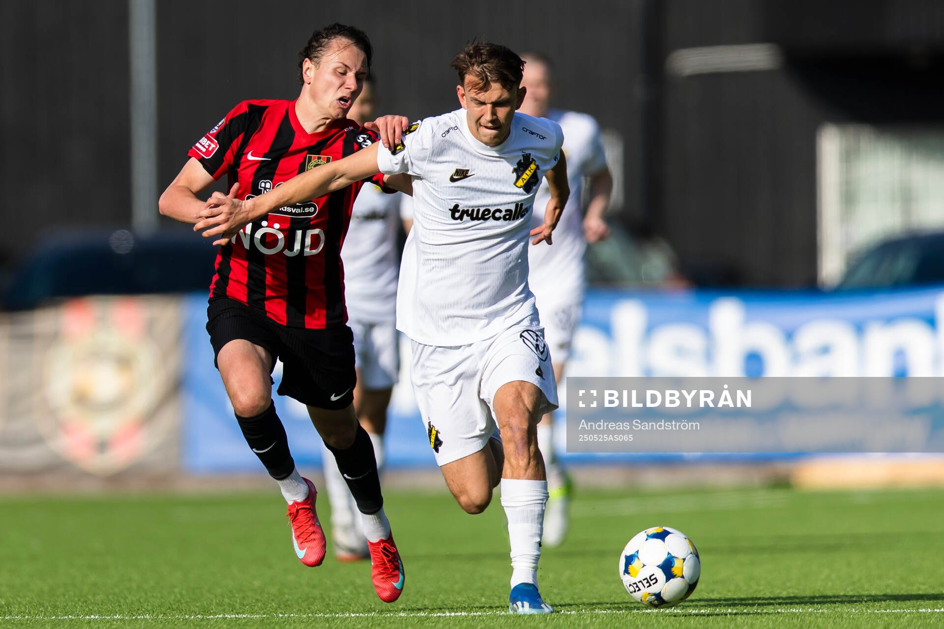 AIKs Kazper Karlsson i kamp om bollen med Brommapojkarnas Alex Timossi Andersson under fotbollsmatchen i Allsvenskan mellan Brommapojkarna och AIK den 25 maj 2025 i Stockholm.