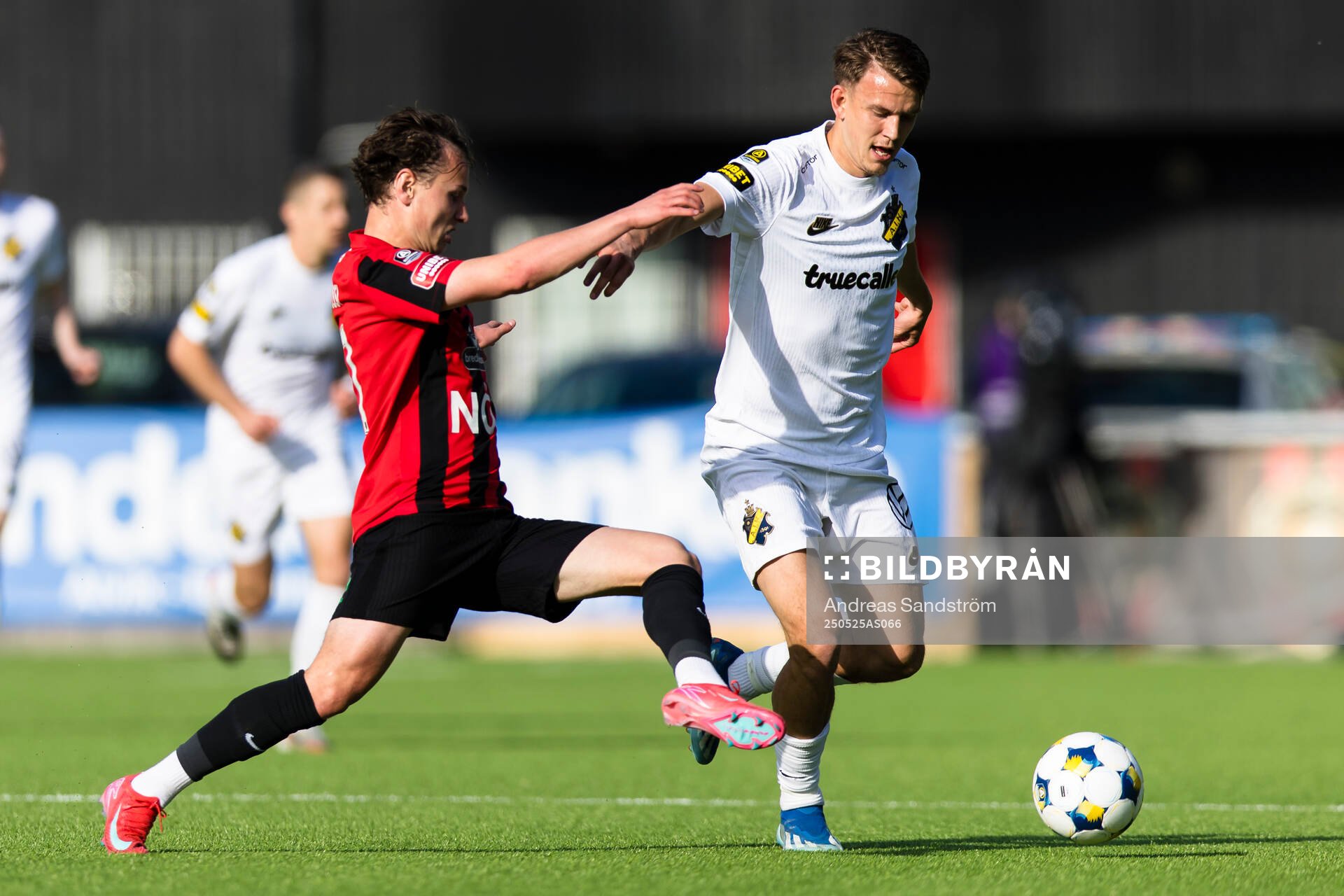 AIKs Kazper Karlsson i kamp om bollen med Brommapojkarnas Alex Timossi Andersson under fotbollsmatchen i Allsvenskan mellan Brommapojkarna och AIK den 25 maj 2025 i Stockholm.