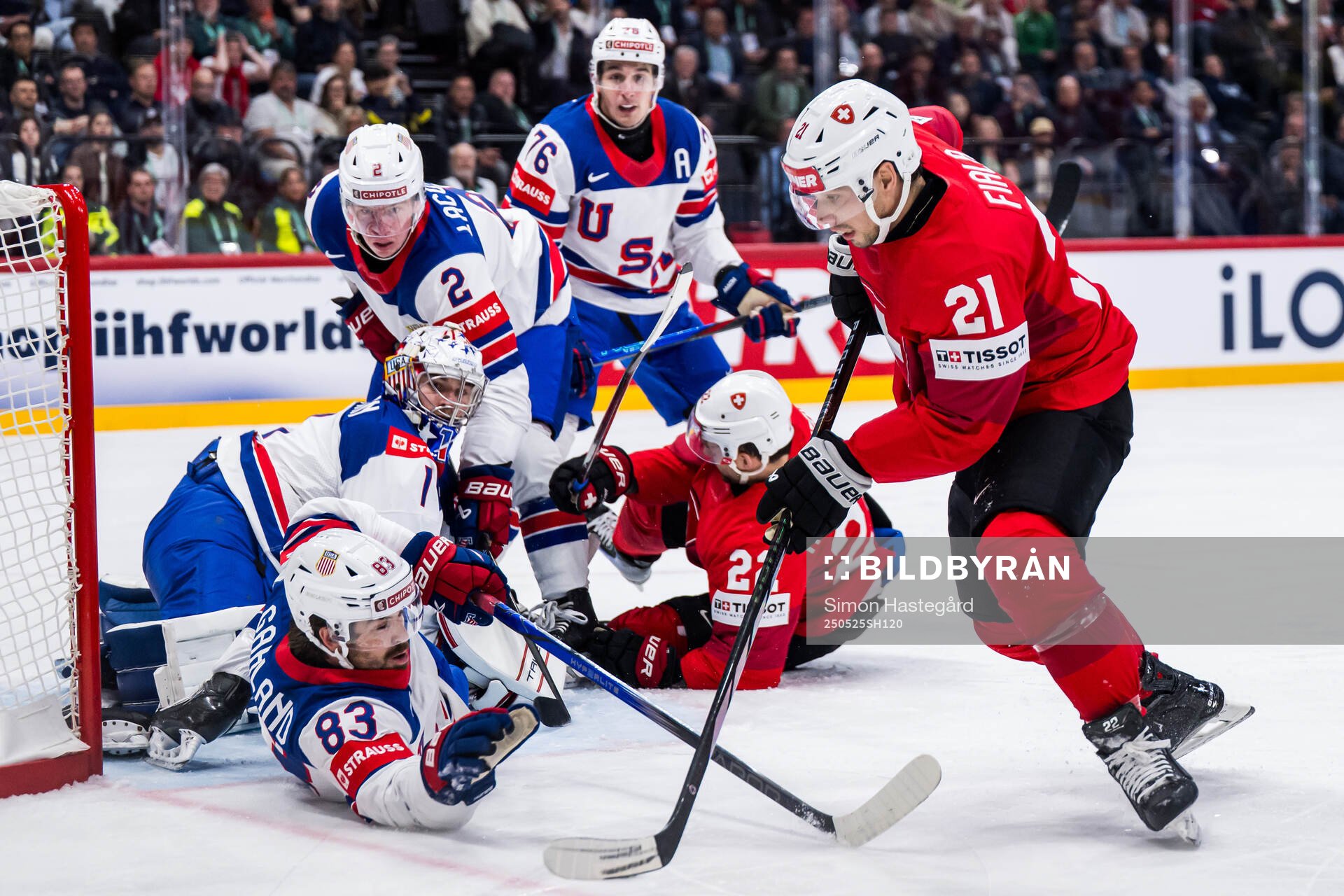 Goaltender Jeremy Swayman and Conor Garland of USA defend