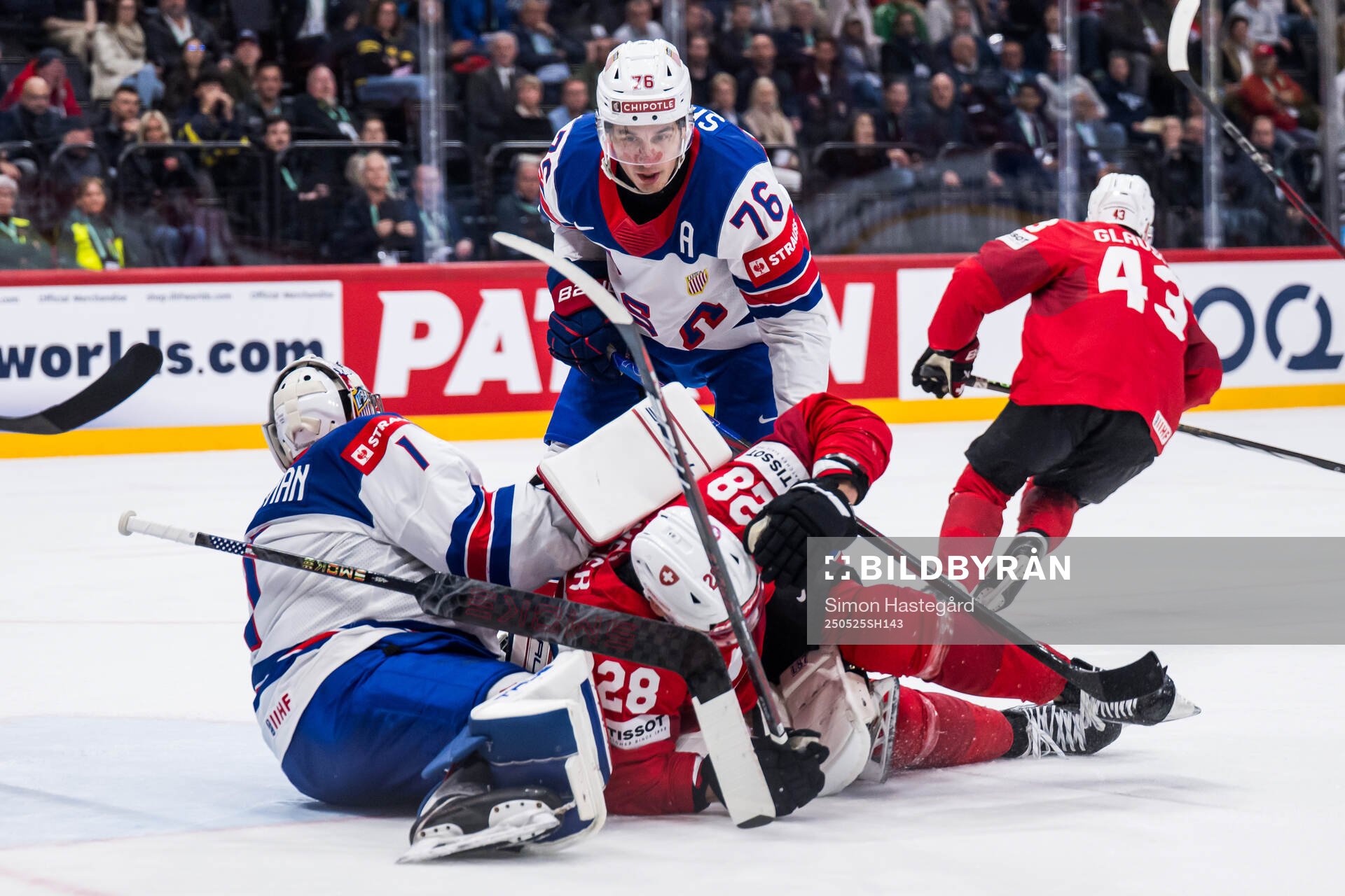 Goaltender Jeremy Swayman and Brady Skjei of USA compete