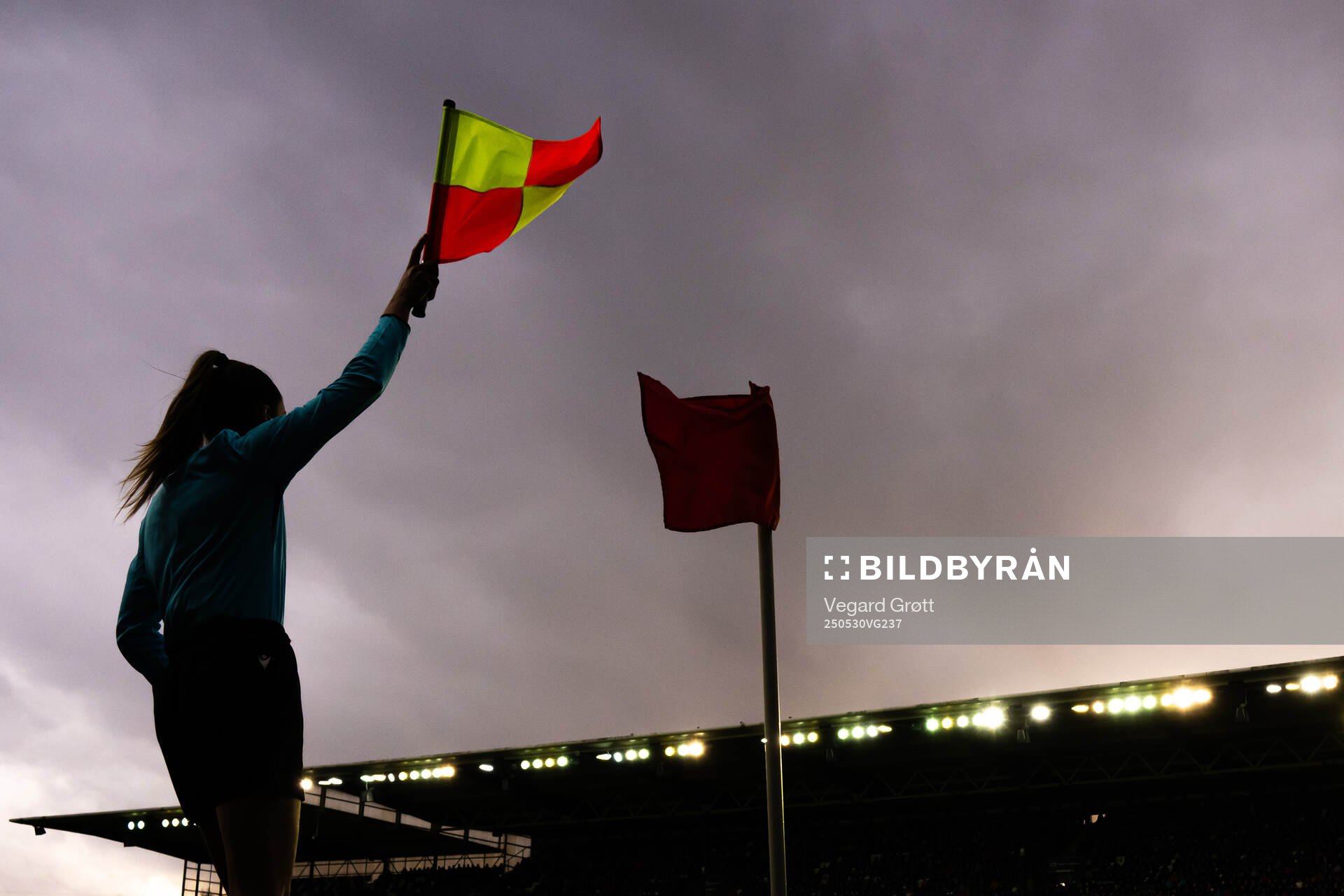 A lineswoman referee waves the flag