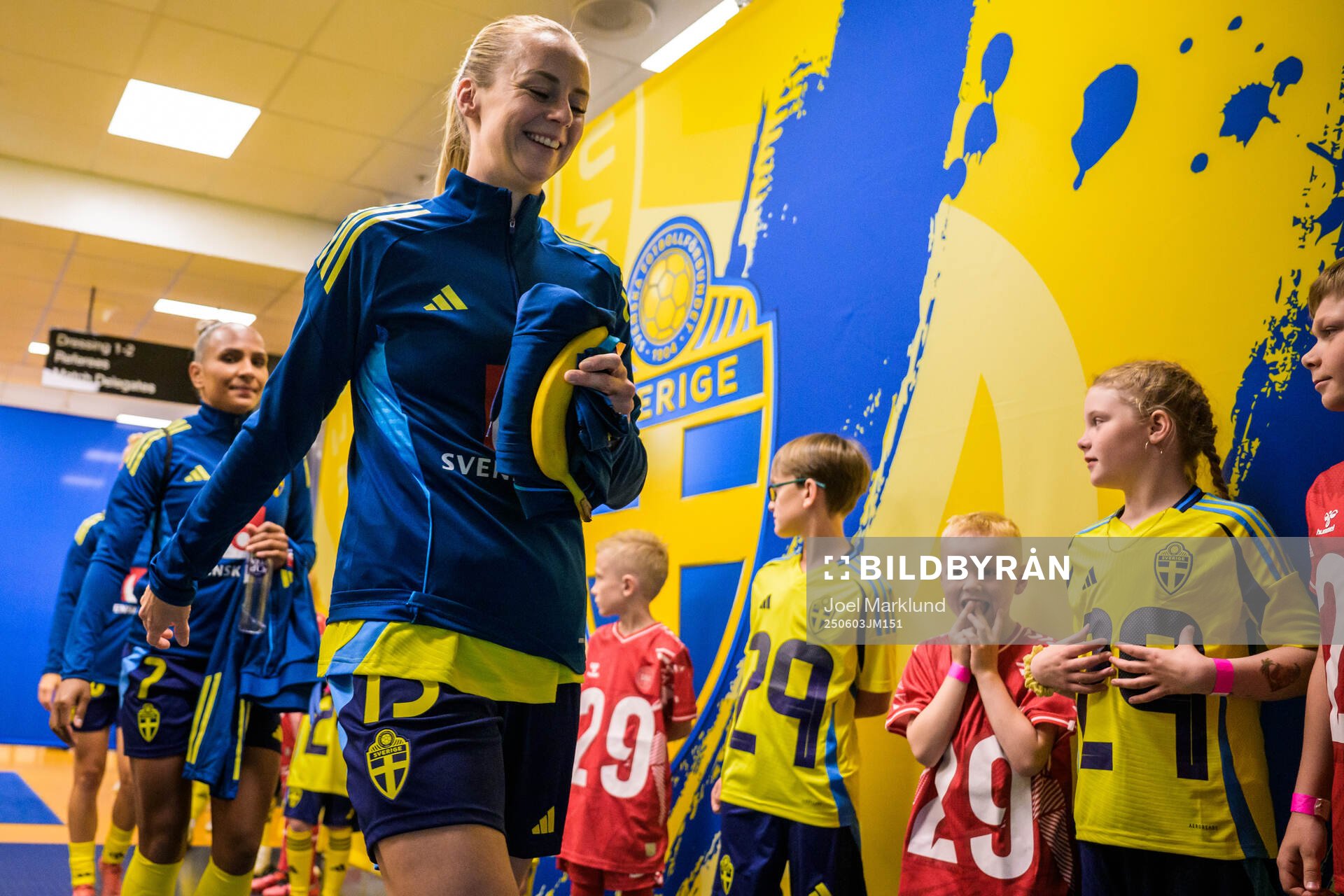 Amanda Ilestedt of Sweden walk by mascots in the player