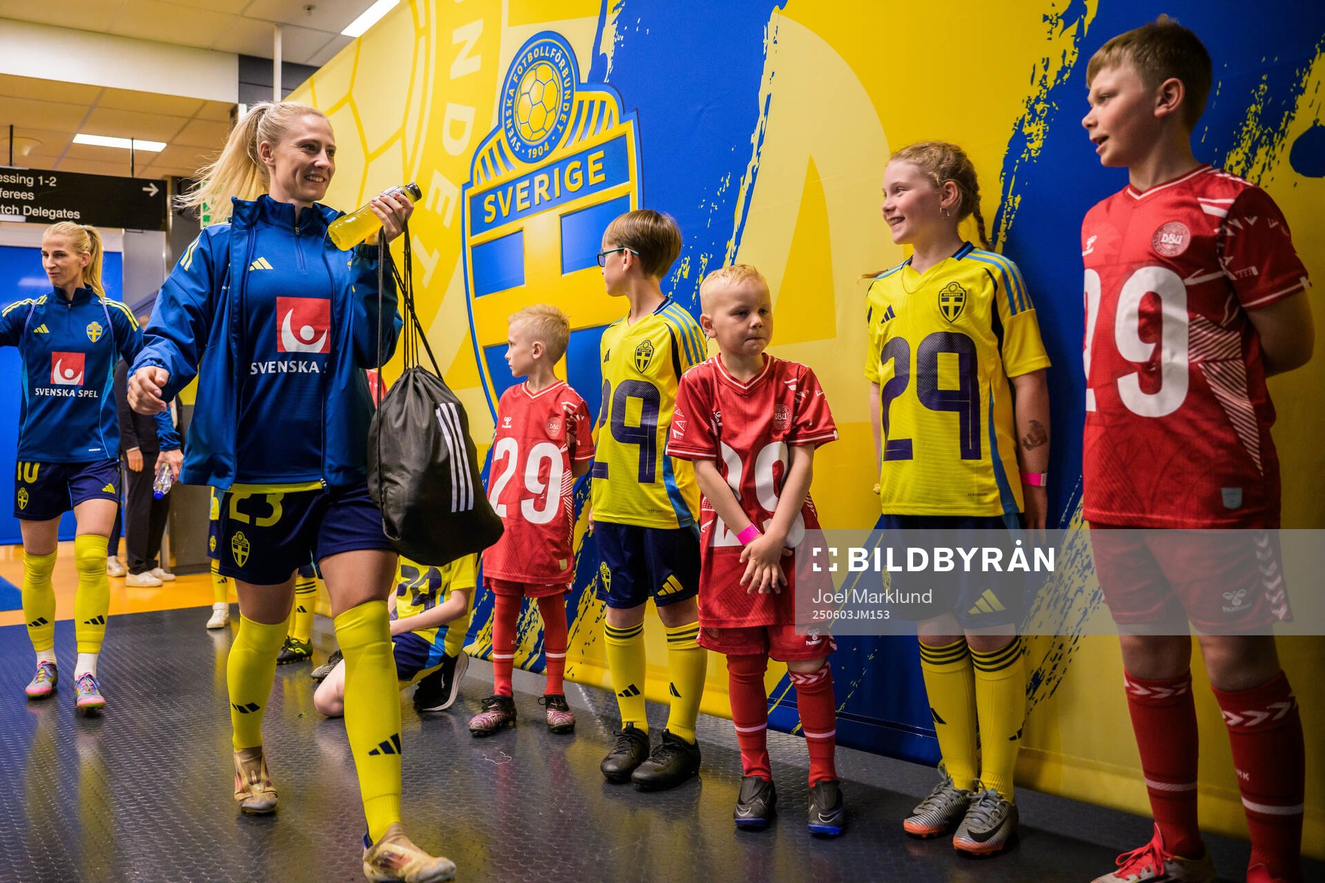 Rebecka Blomqvist of Sweden walk by mascots in the player