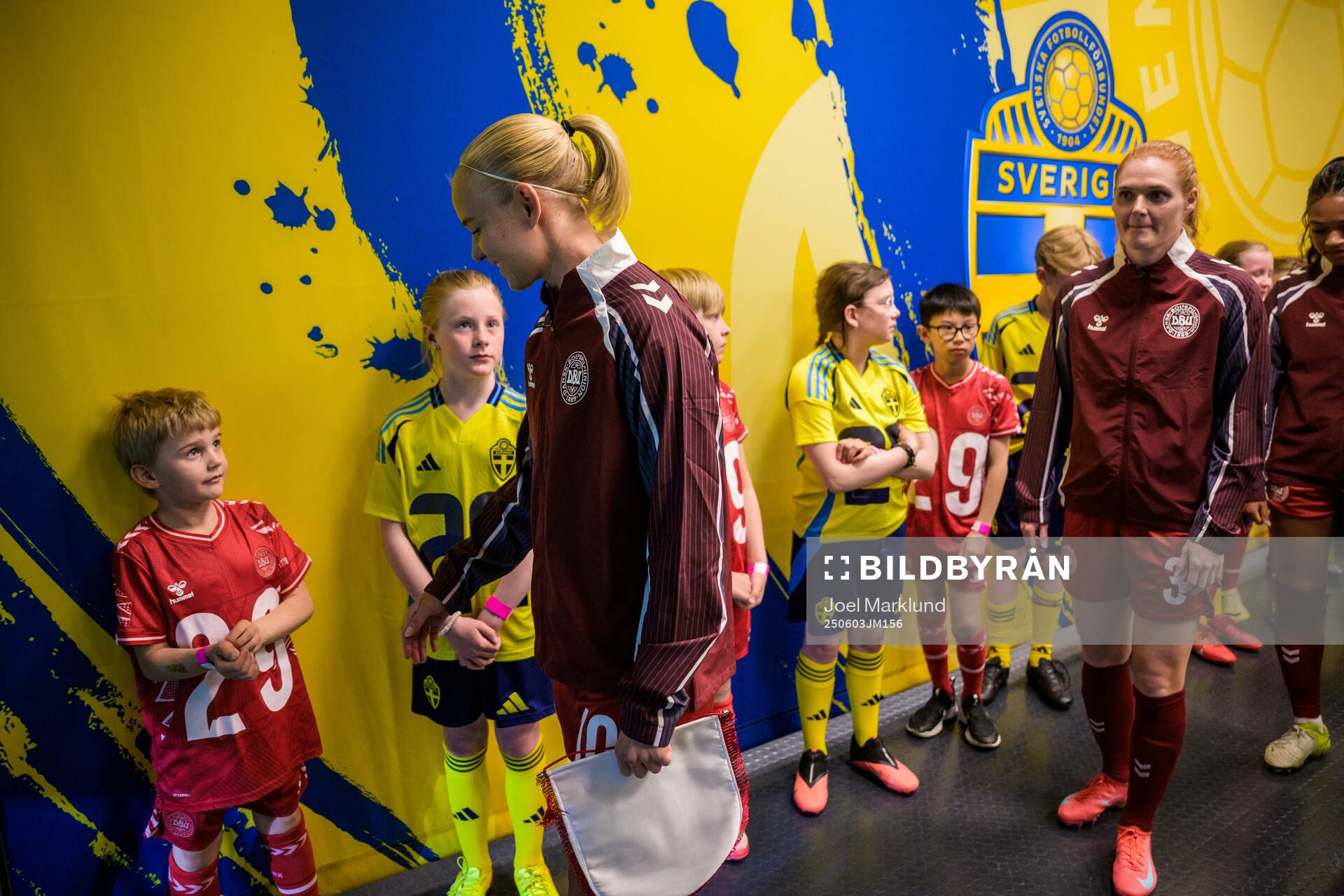 Pernille Harder of Denmark next to mascots in the player