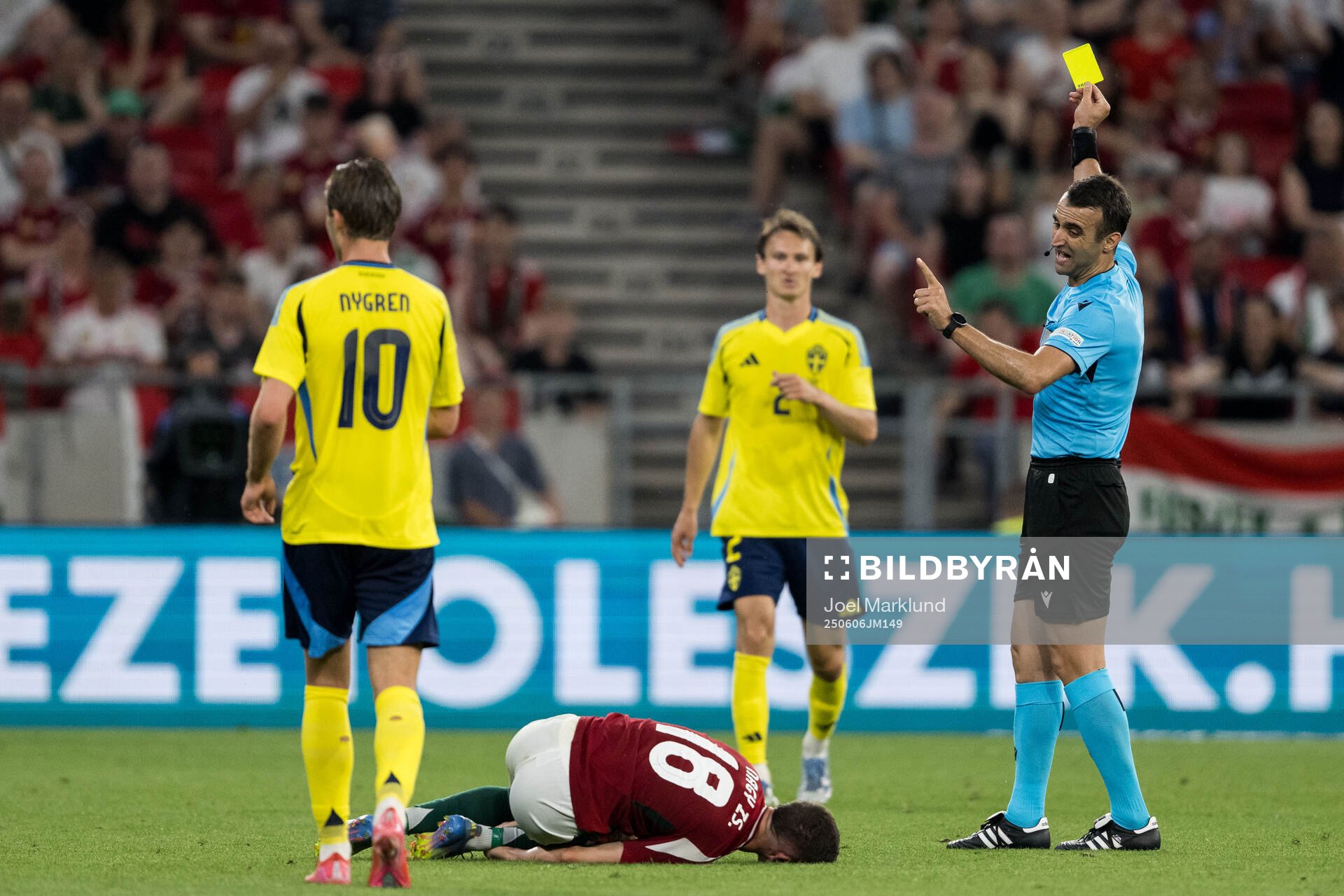 Hjalmar Ekdal of Sweden receives a yellow card from referee