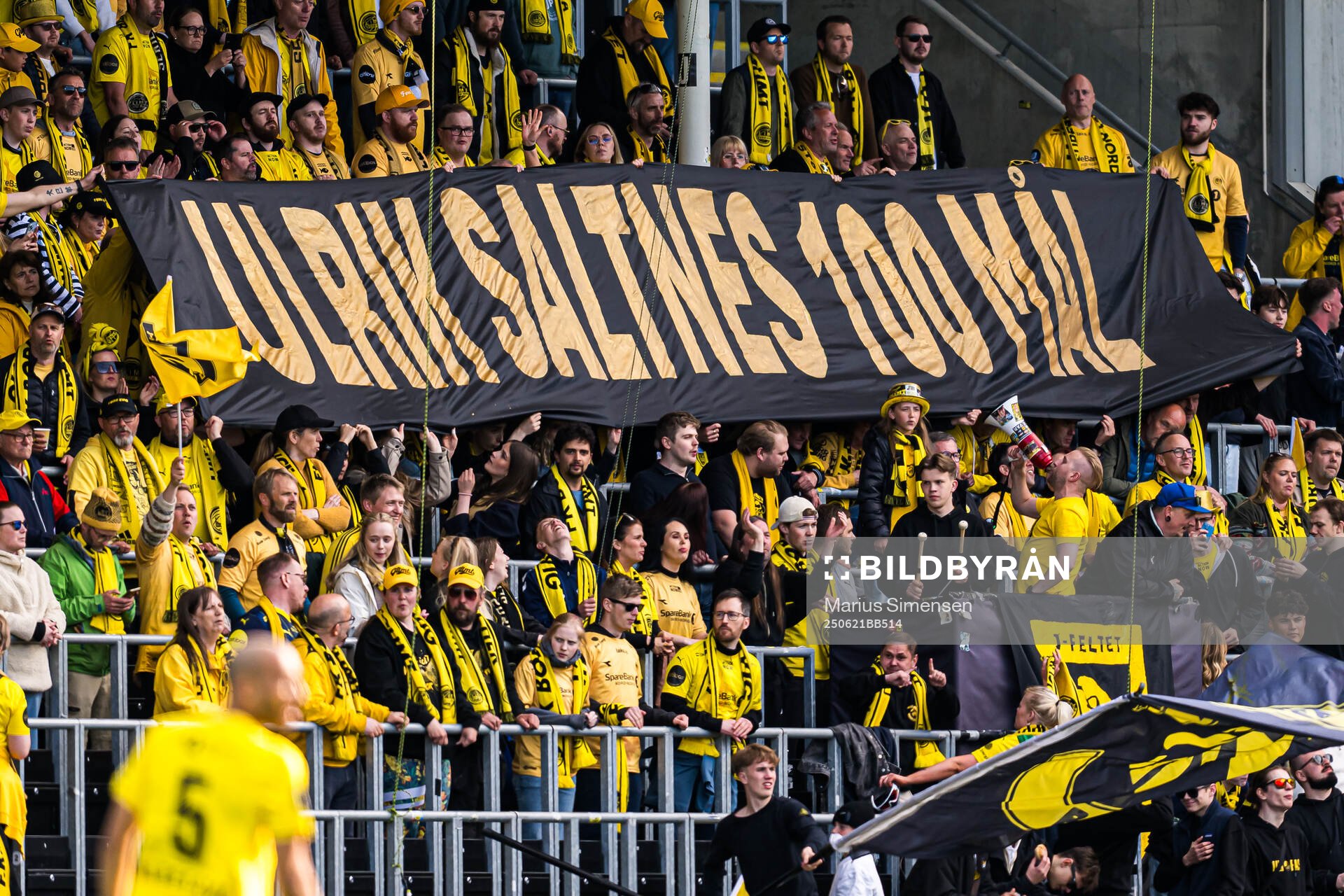 Spectators in the stands with a banner