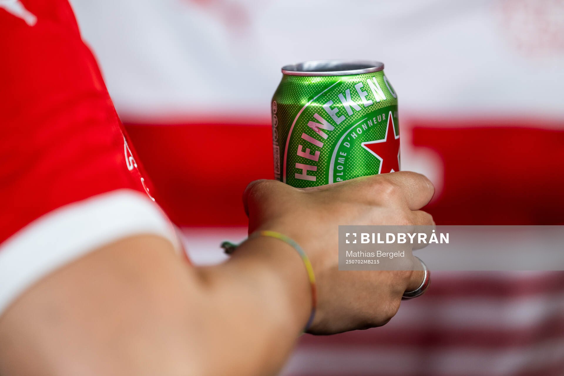 A spectator holds a beer can