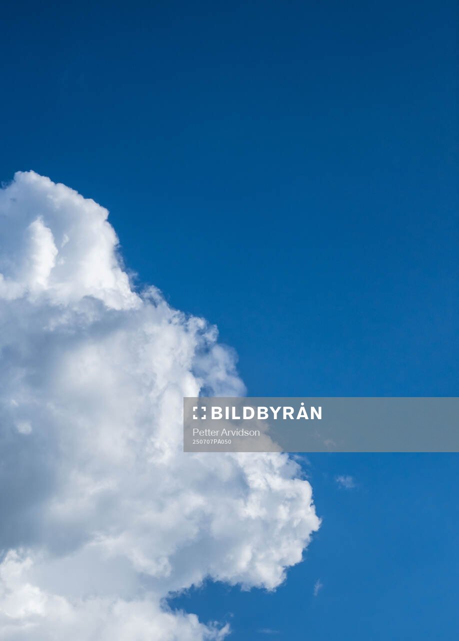 A cloud and a blue sky is seen