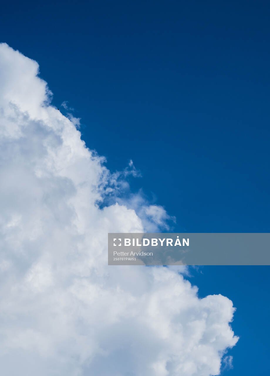 A cloud and a blue sky is seen