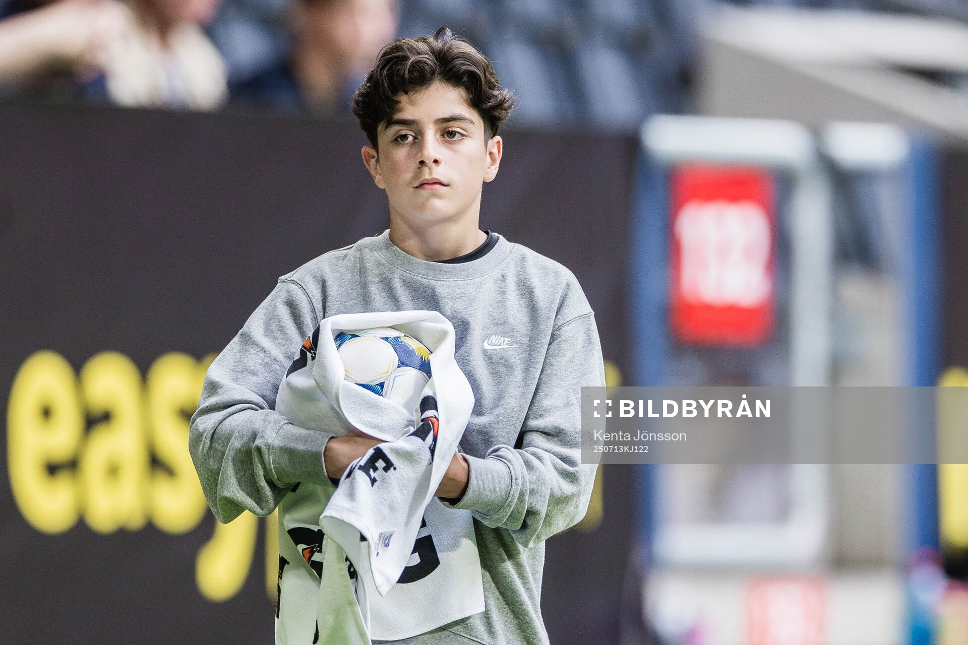 En bollkalle torkar en matchboll med handduk