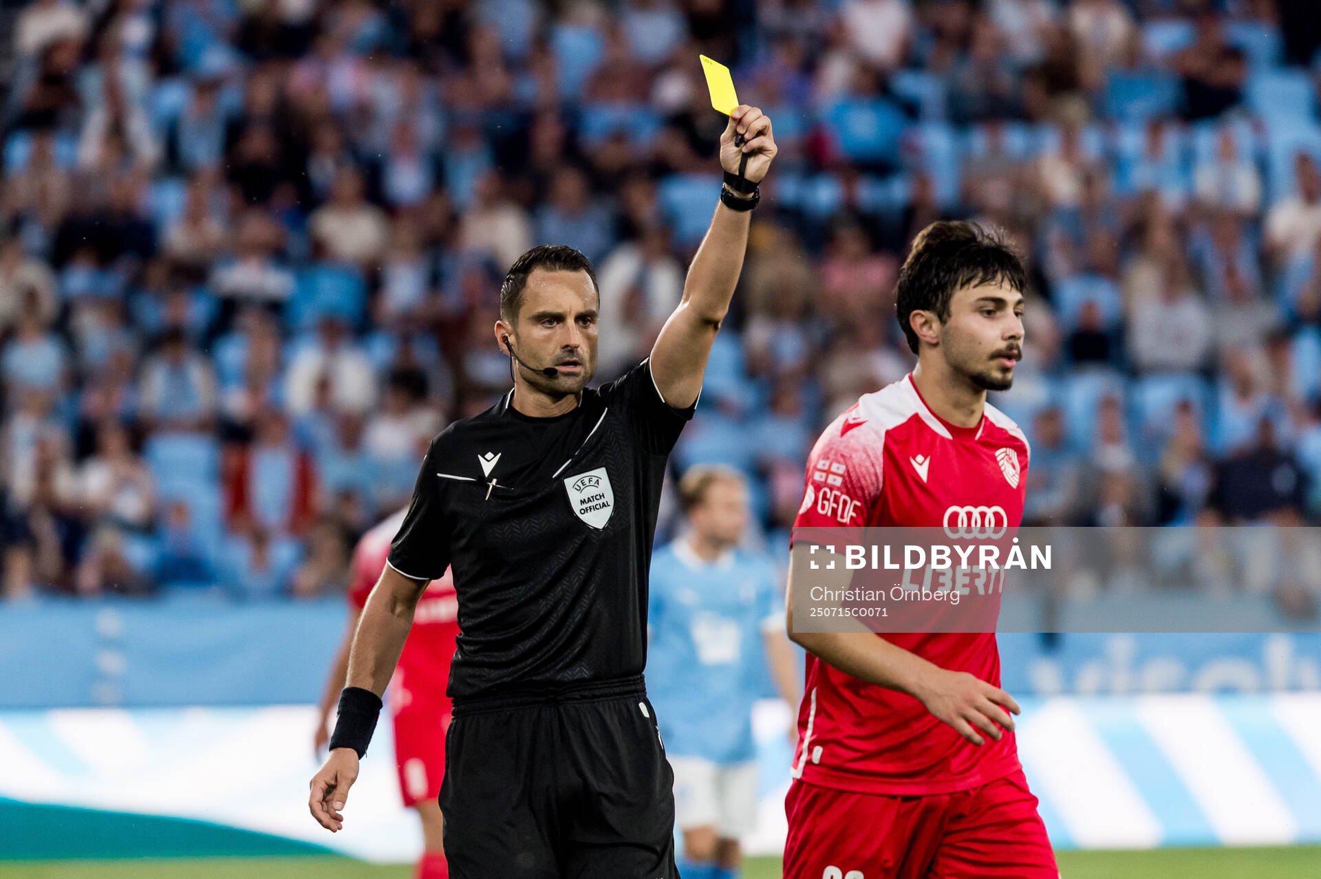 Giorgi Tabatadze of FC Iberia is shown a yellow card from