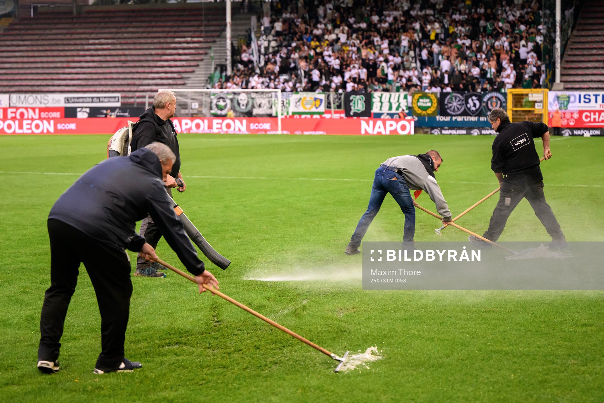 Officials remove water from the pitch