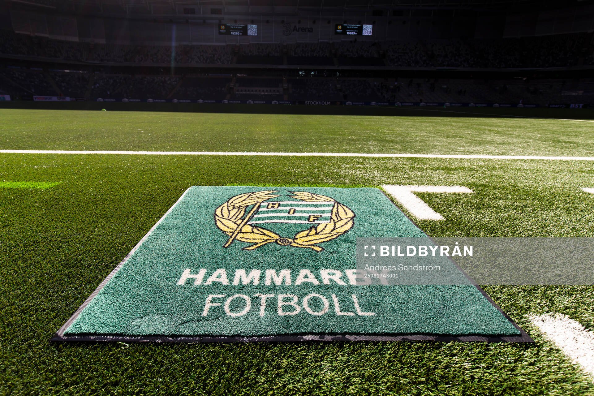 En matta med Hammarbyls klubbmärke ligger på konstgräset