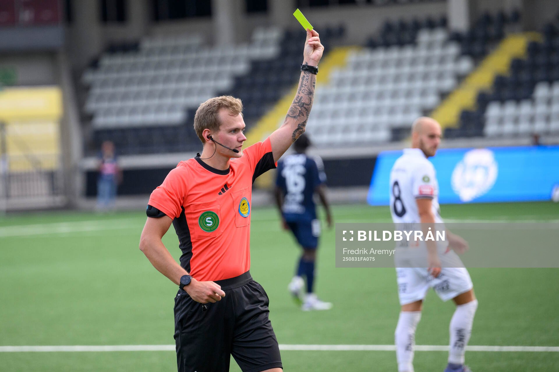 Domare Fredrik Alknäs visar upp ett gult kort