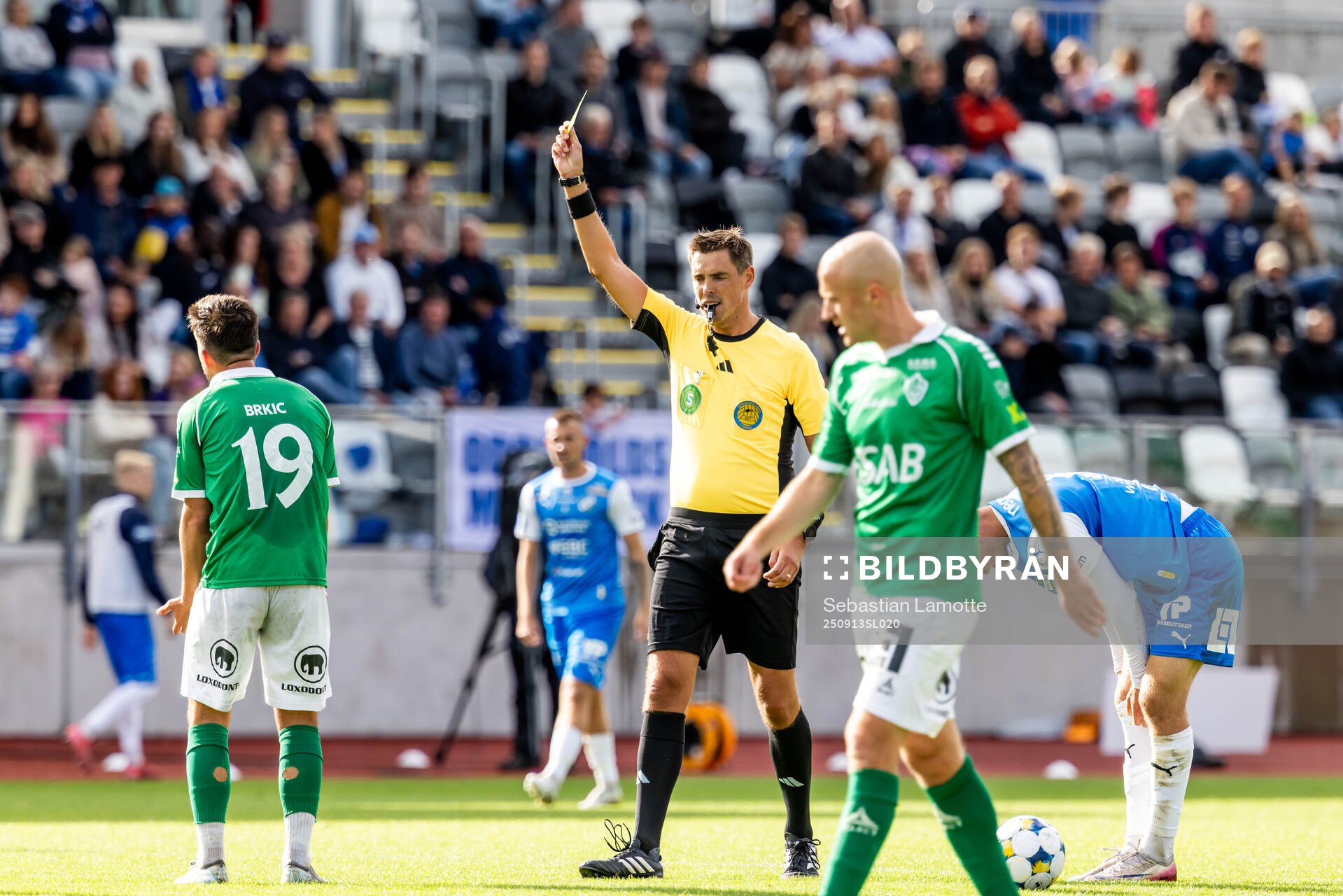 Domare Magnus Lindgren visar Brages Haris Brkic gult kort