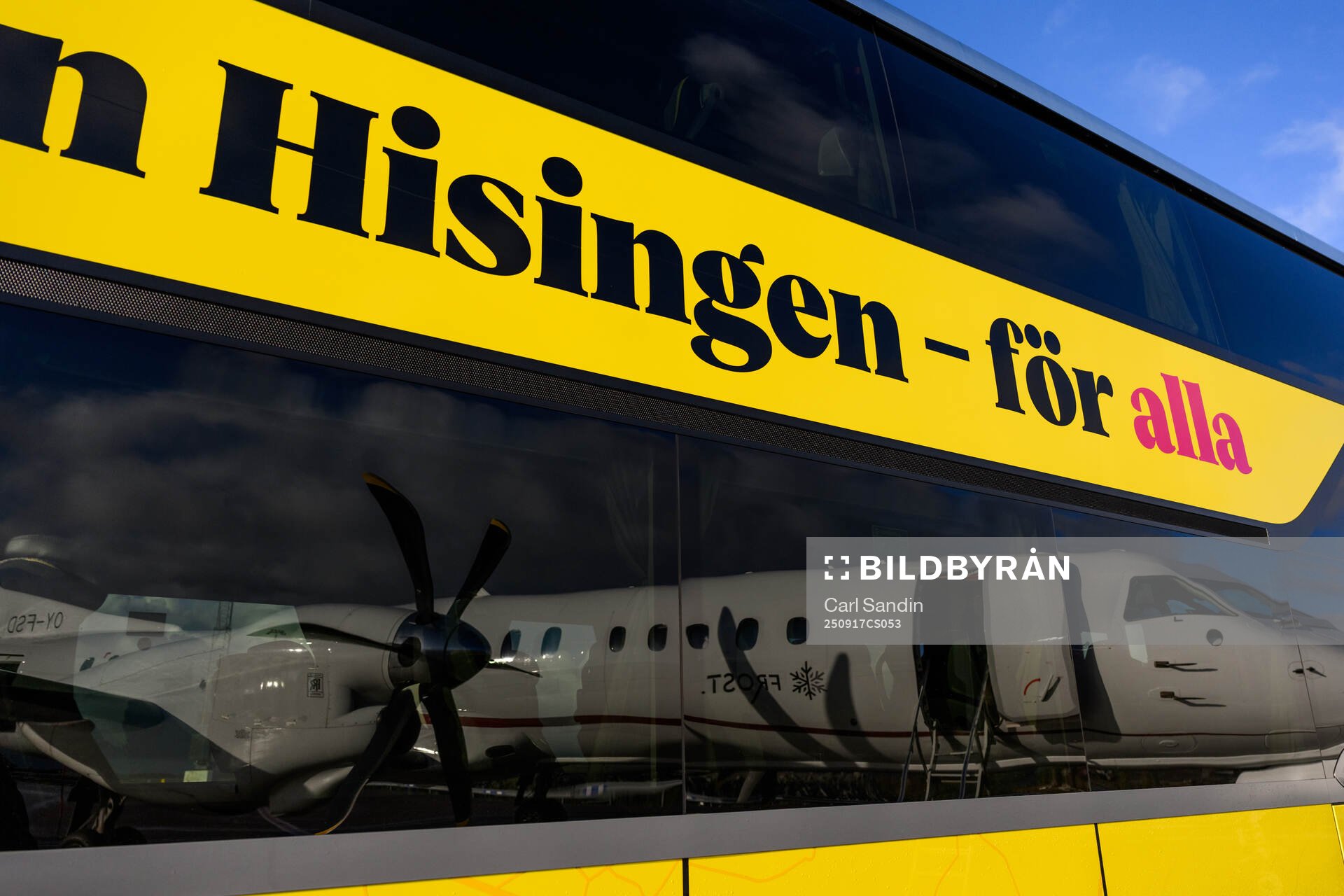 The reflection of an airplane in the windows of a bus