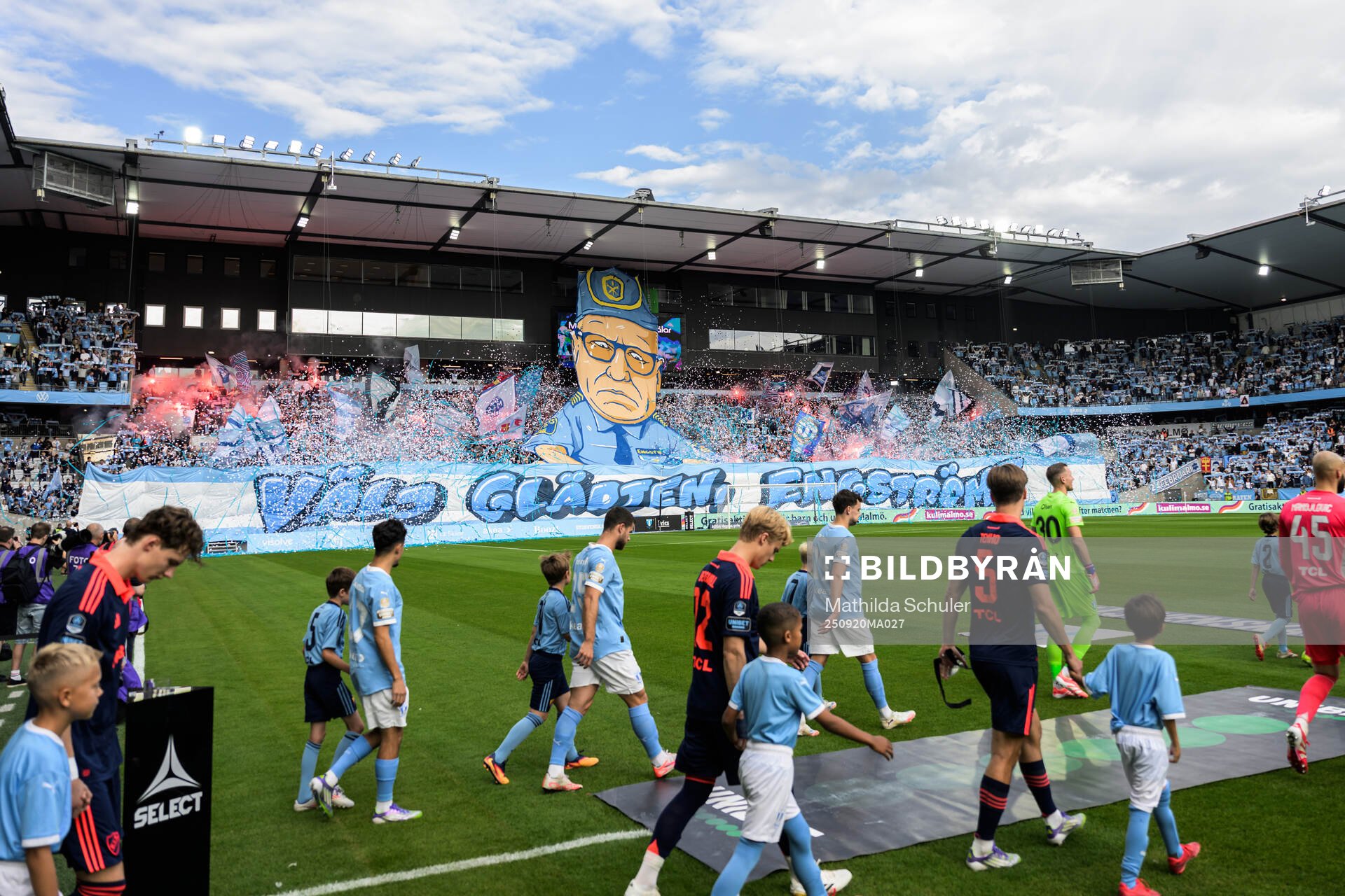 Spelare framför Malmös supportrars tifo föreställande