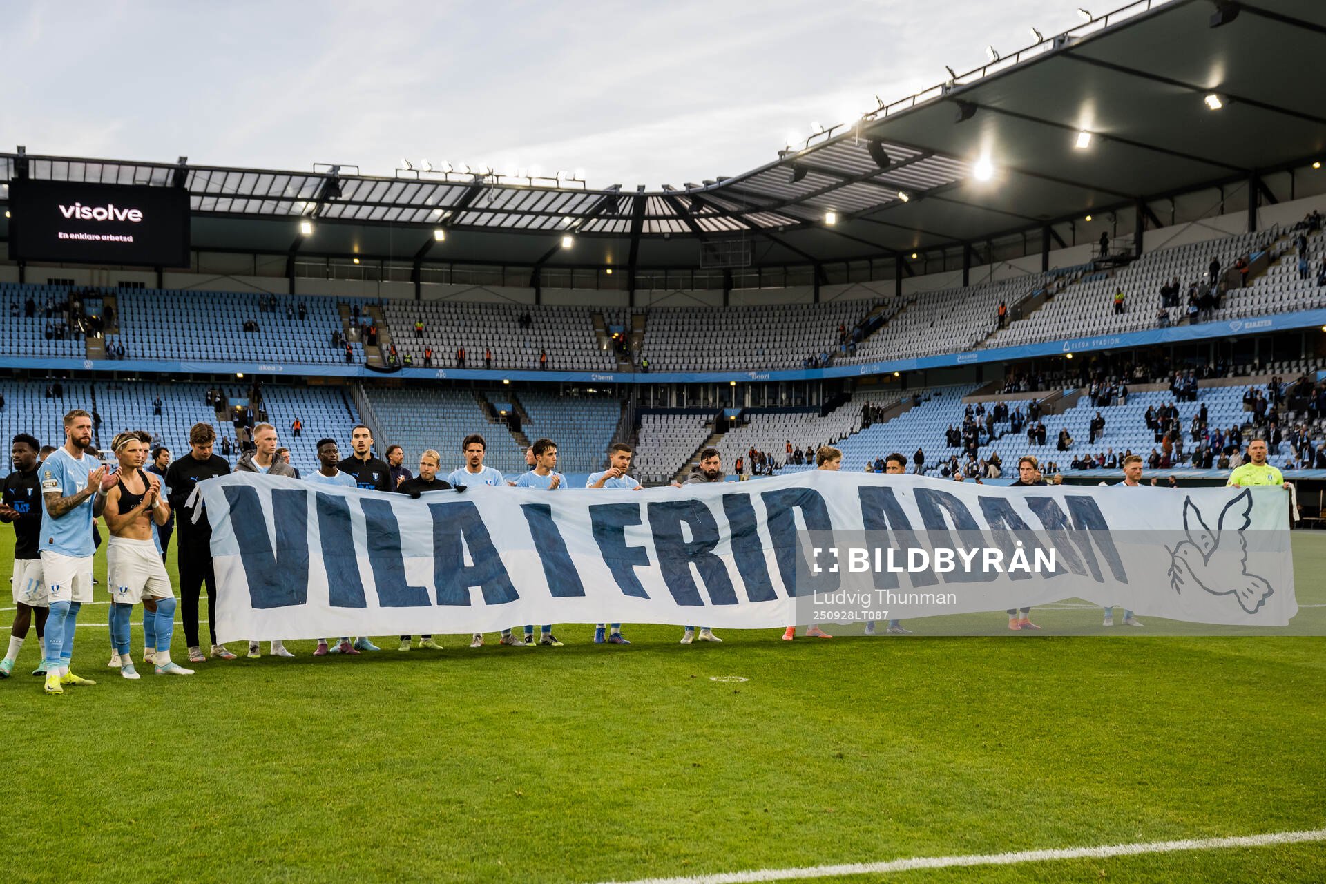 Malmö FFs spelare med en banderoll för att hedra en