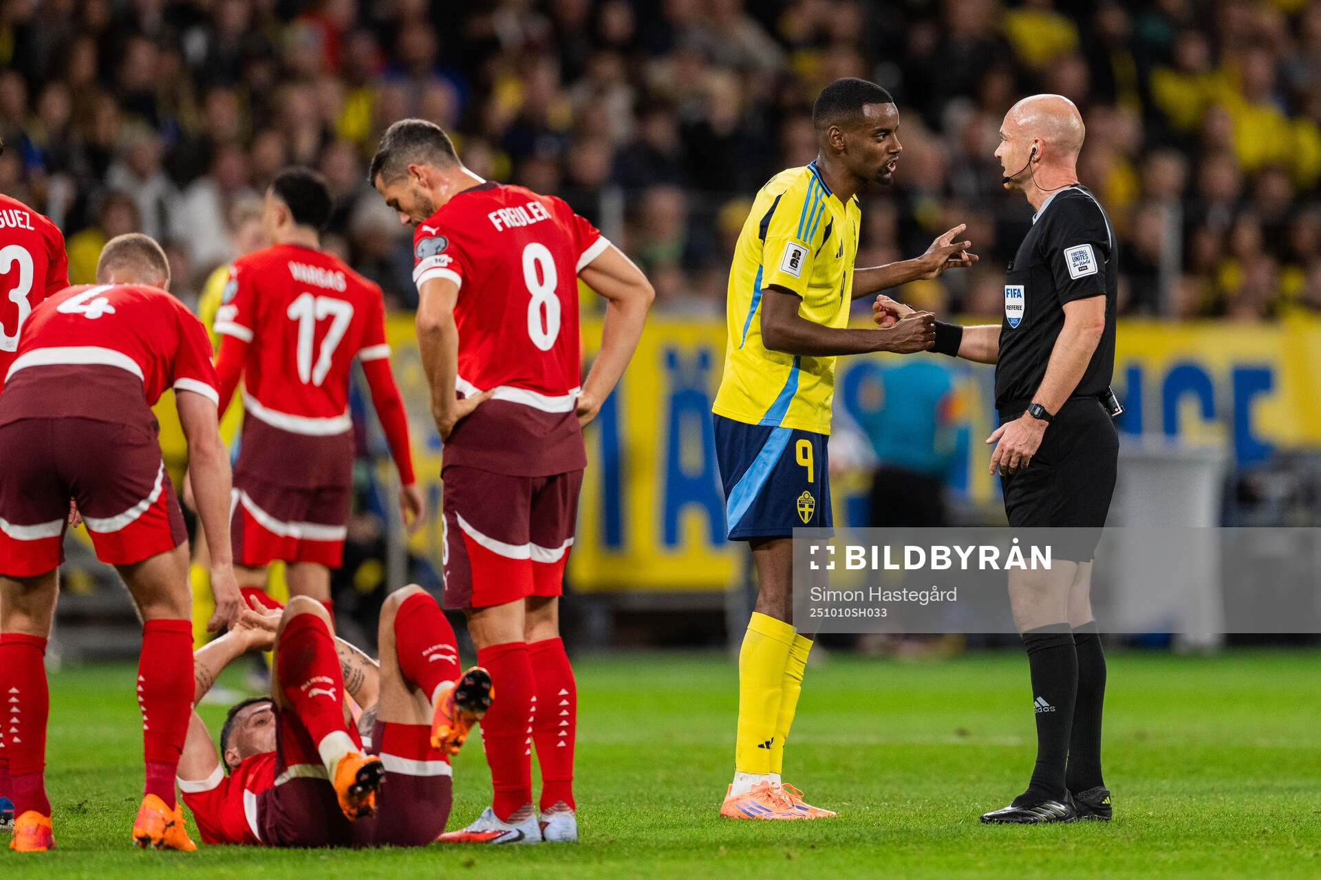 Alexander Isak of Sweden and referee Anthony Taylor