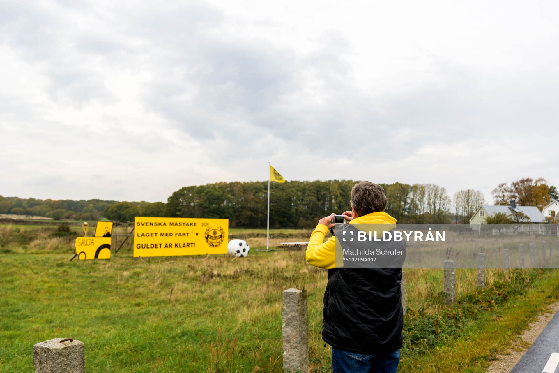 Mjällby supporter tar en bild på en skylt som hyllar laget