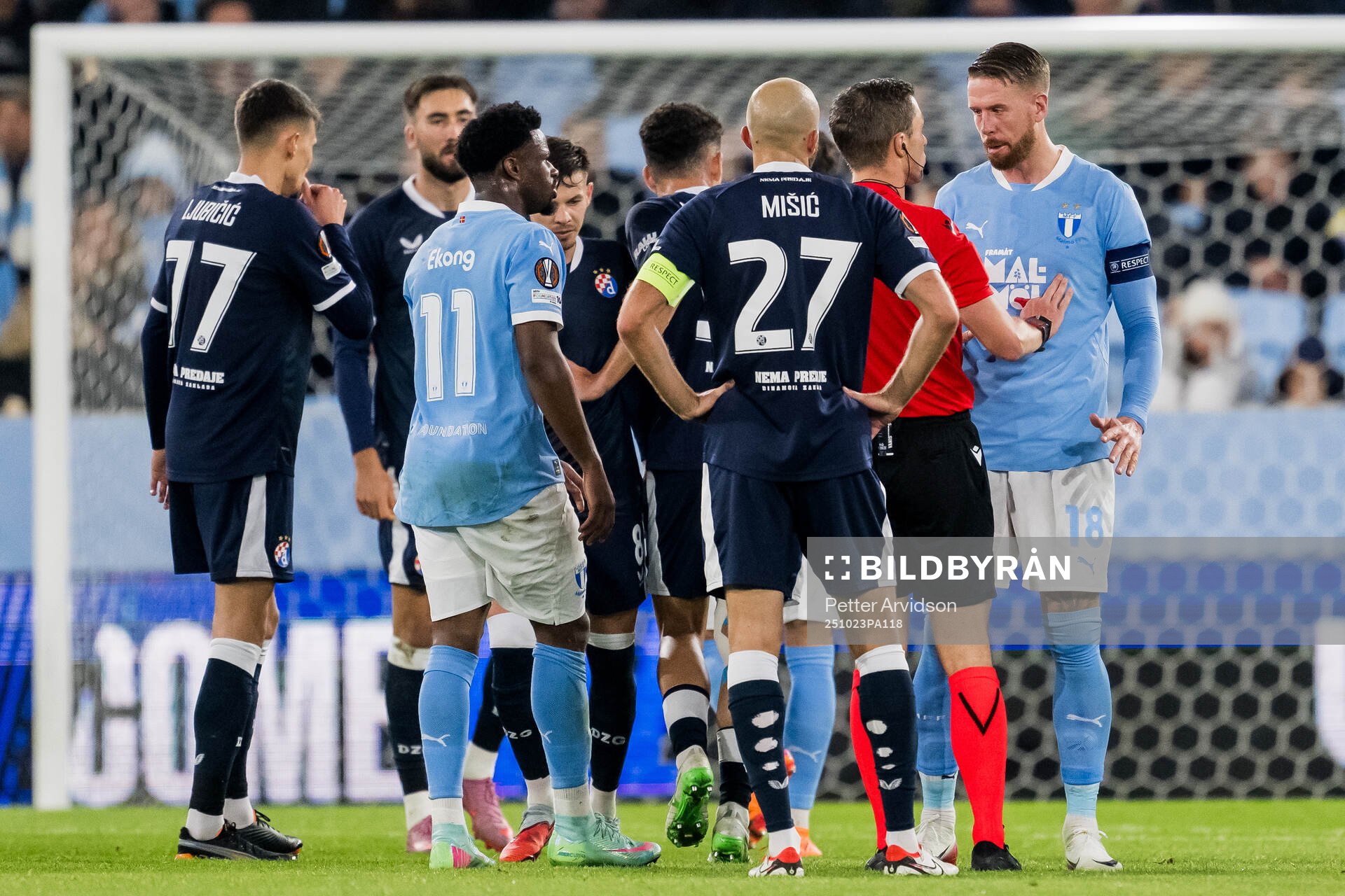 Referee Willy Delajod and Pontus Jansson of Malmö FF