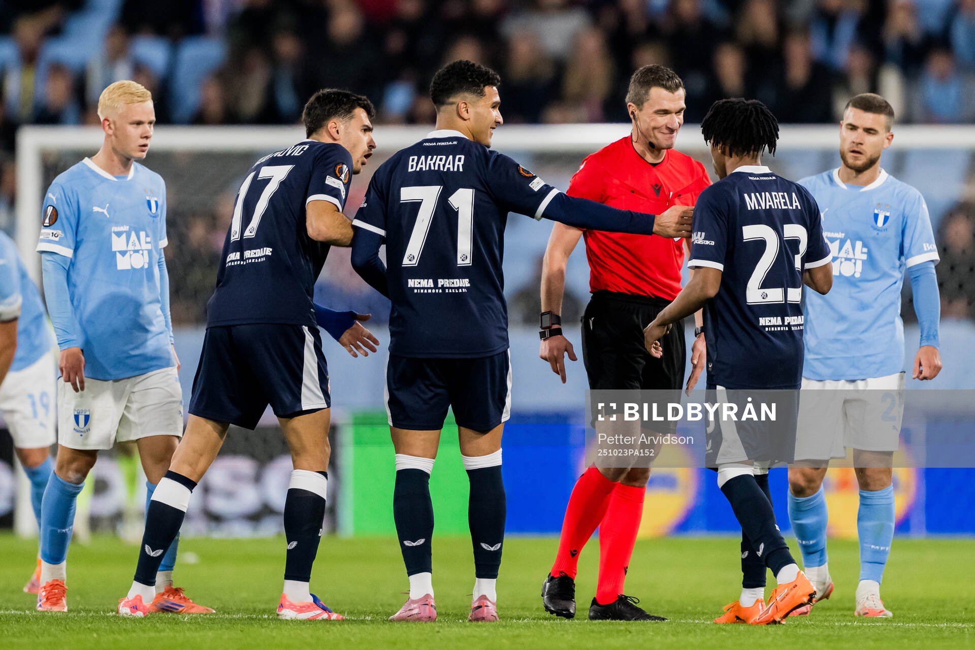 Referee Willy Delajod and Cardoso Varela of Dinamo Zagreb