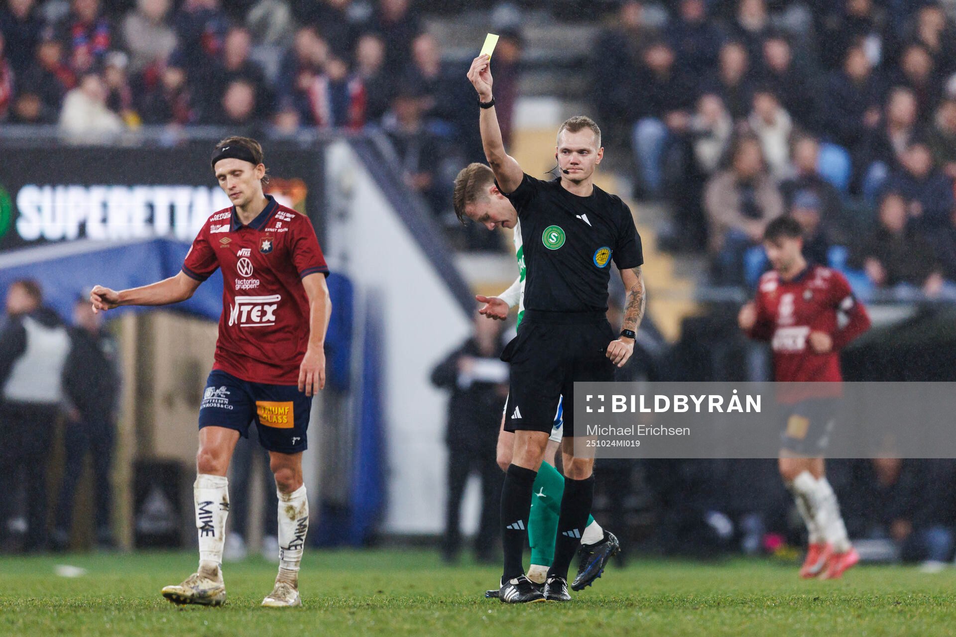 Domare Fredrik Alknäs delar ut ett gult kort till