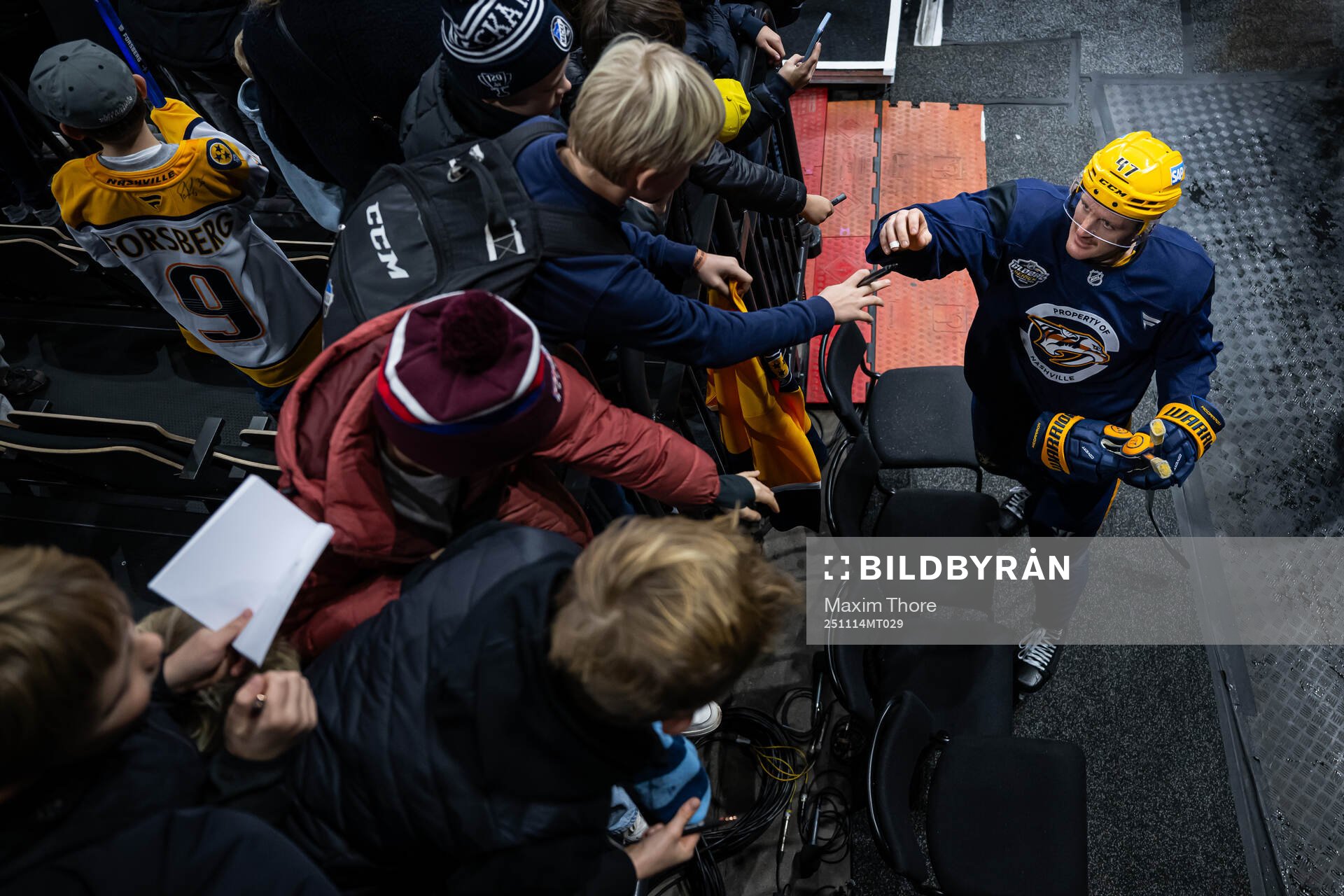 Michael McCarron writes autographs to young fans