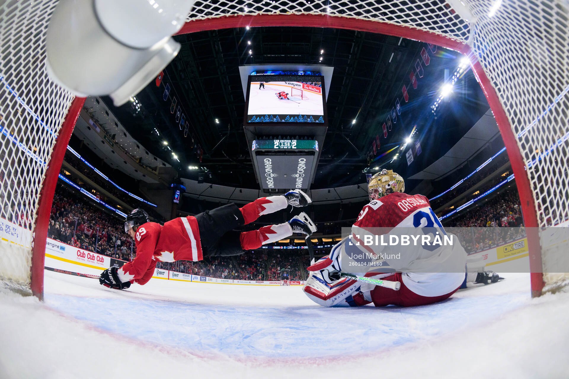 Michael Hage of Canada is being tripped by goaltender