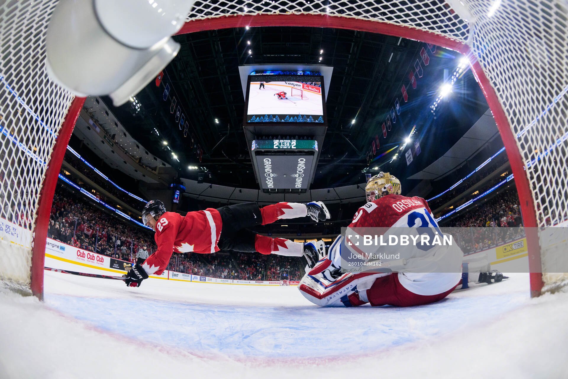 Michael Hage of Canada is being tripped by goaltender
