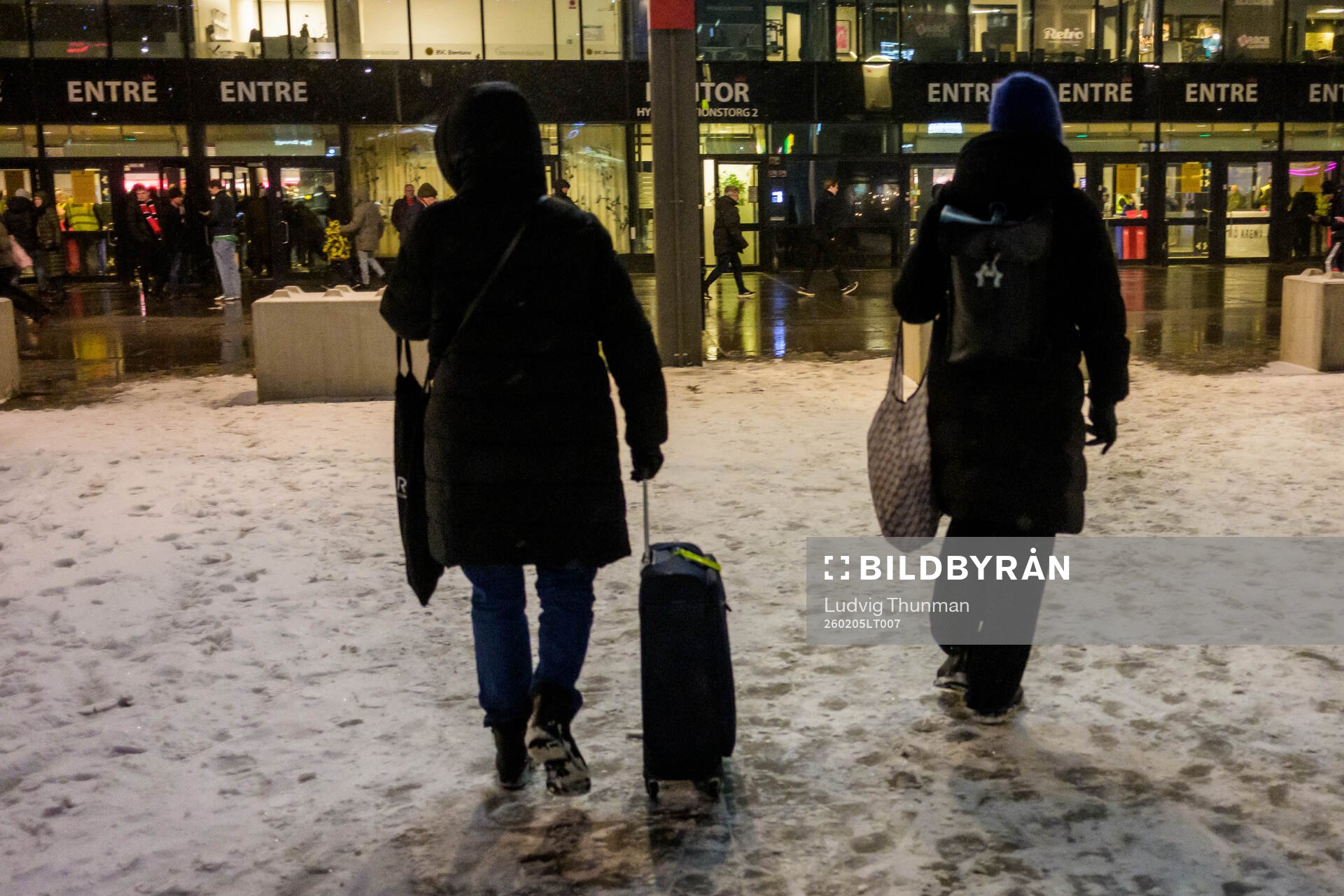 En person drar en rullväska i snön