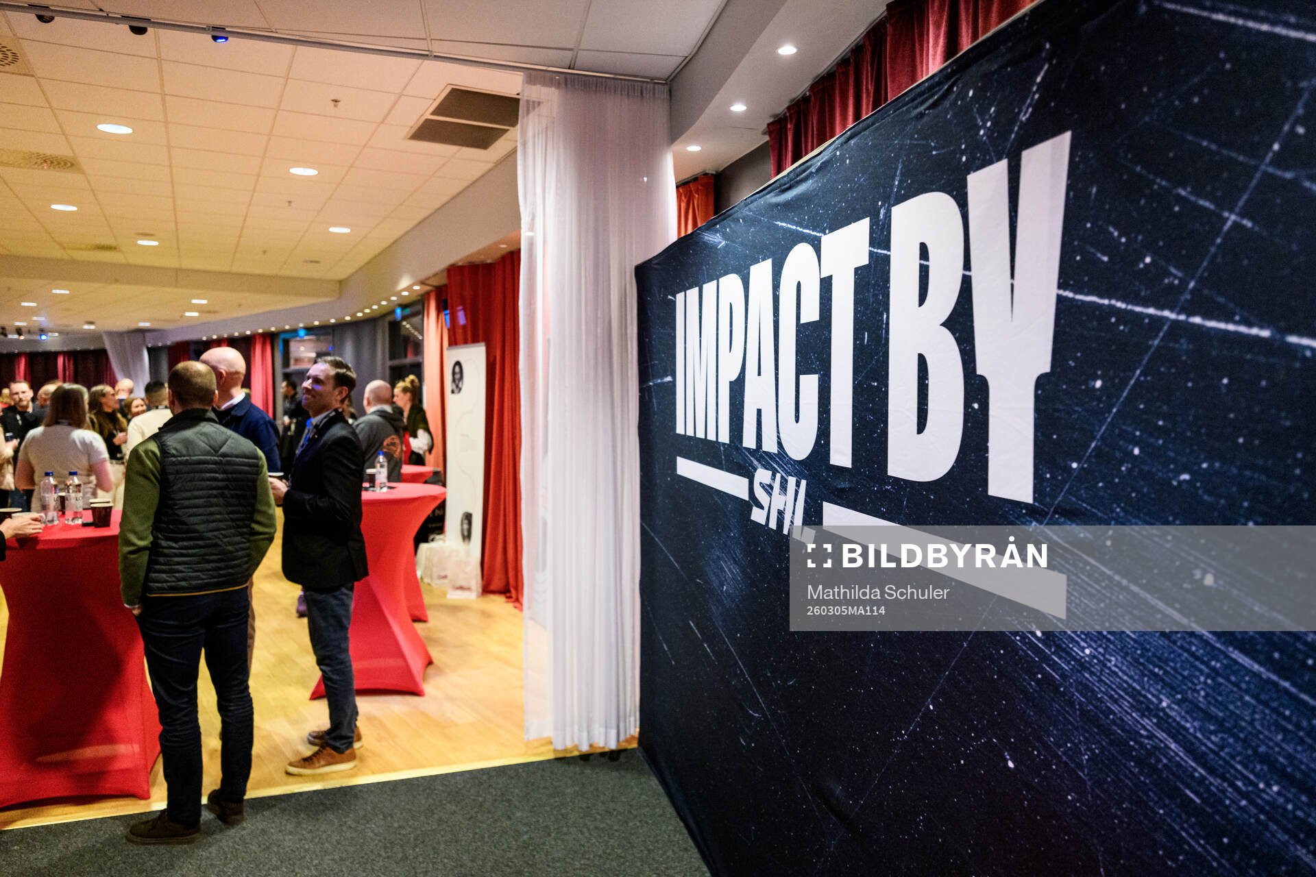 En skylt med Imapct By SHL