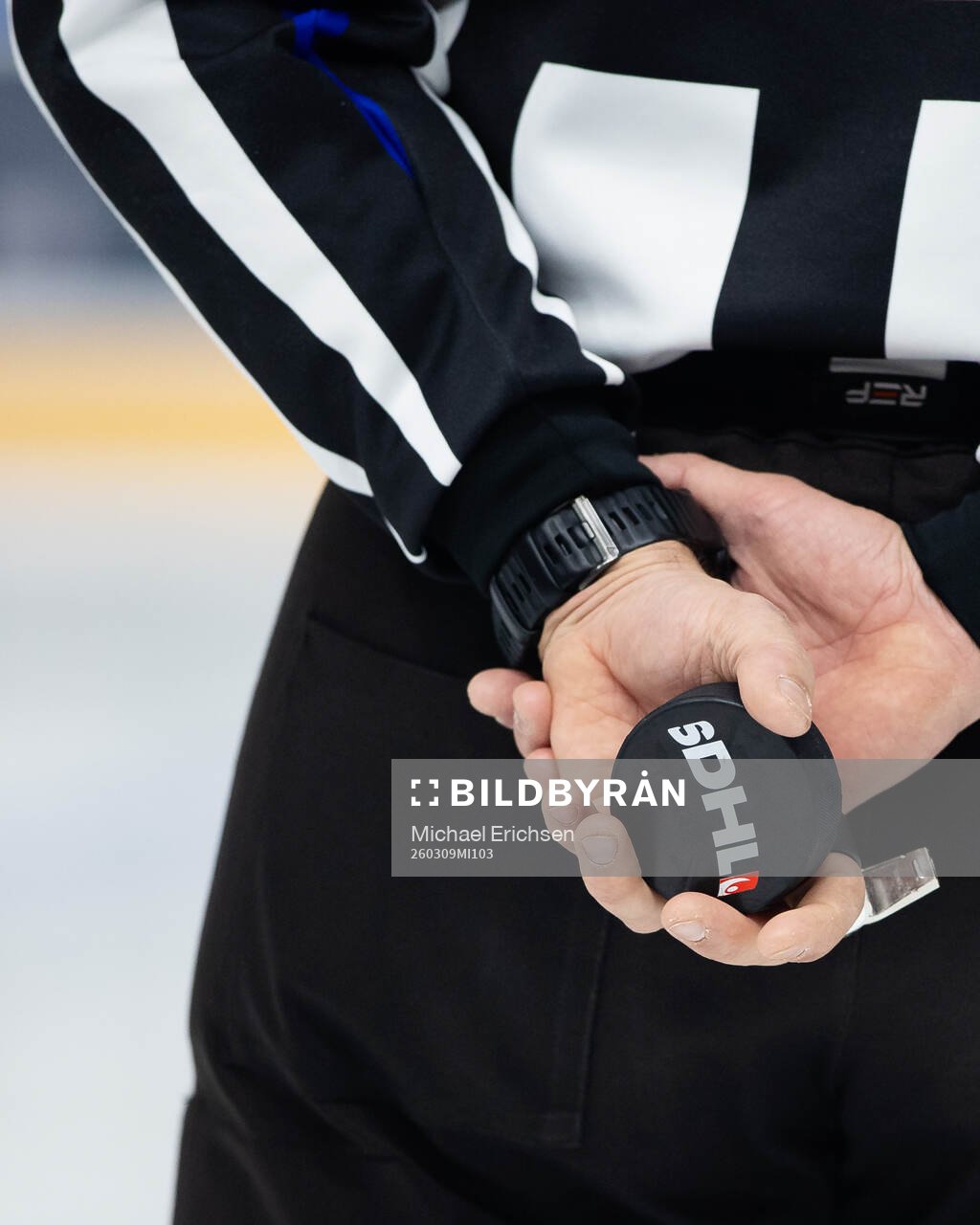En domare med en puck i händerna