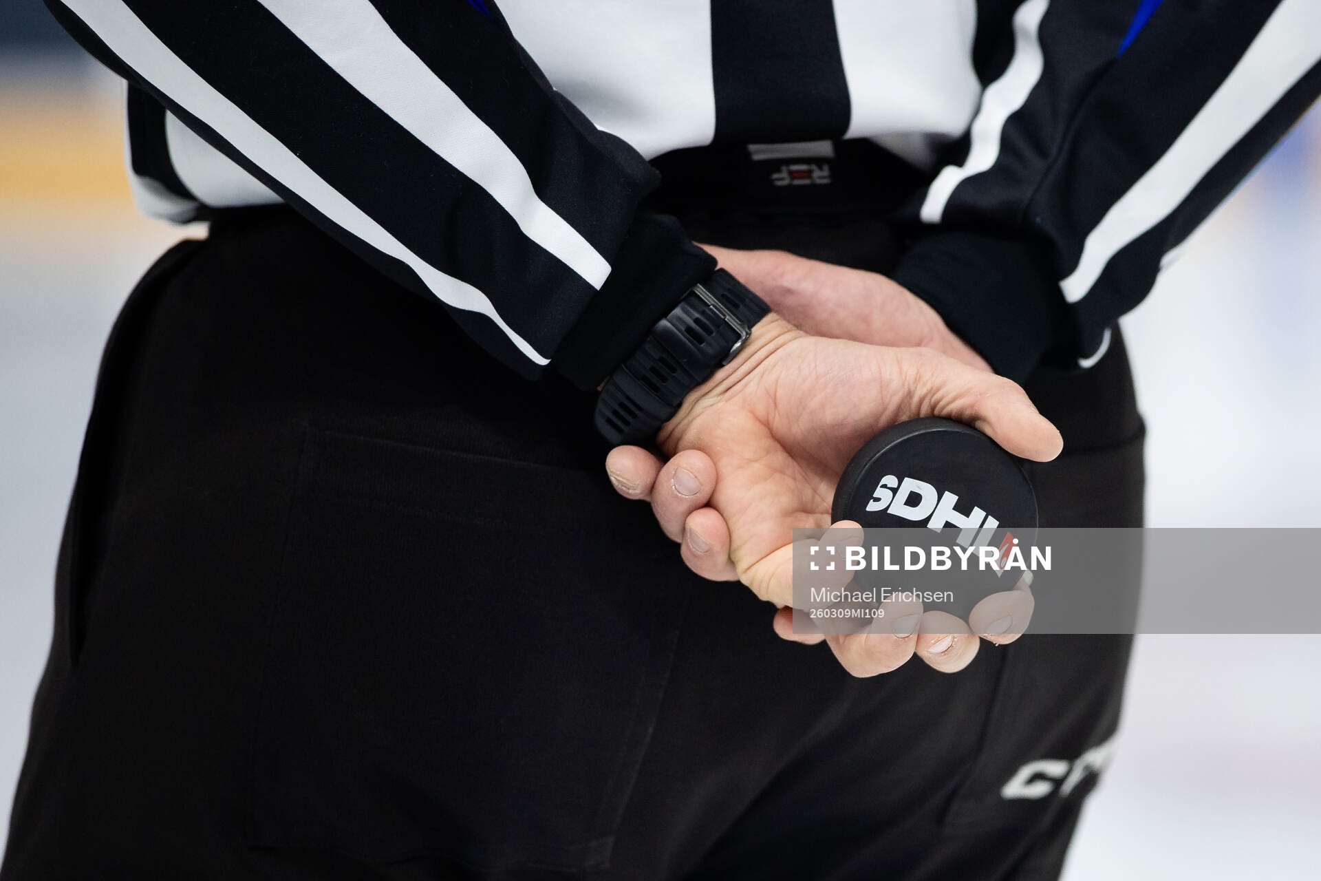 En domare med en puck i händerna