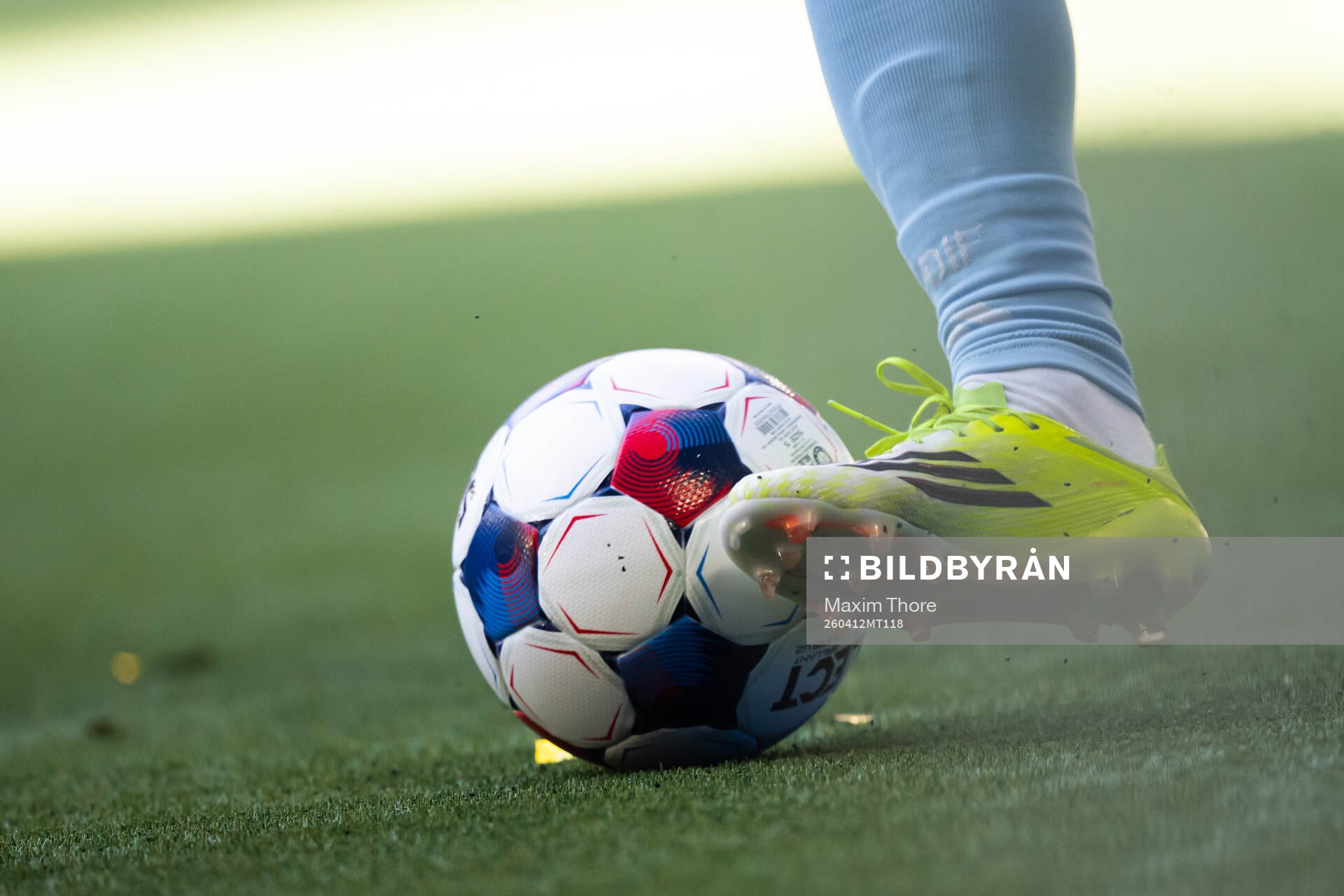 En fotboll och fotbollsko på konstgräs