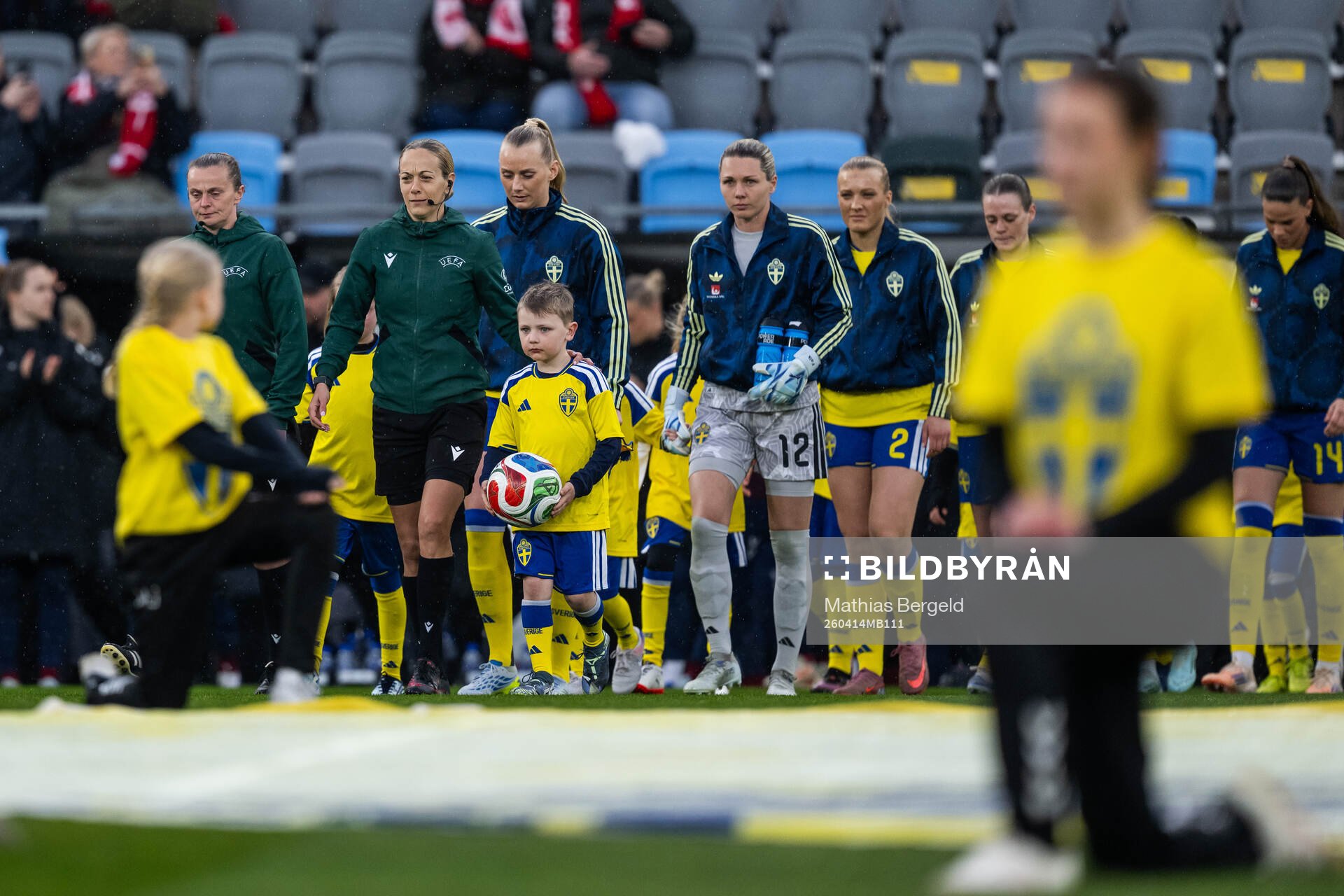 A mascot carrying the ball next to referee Ivana Martinčić