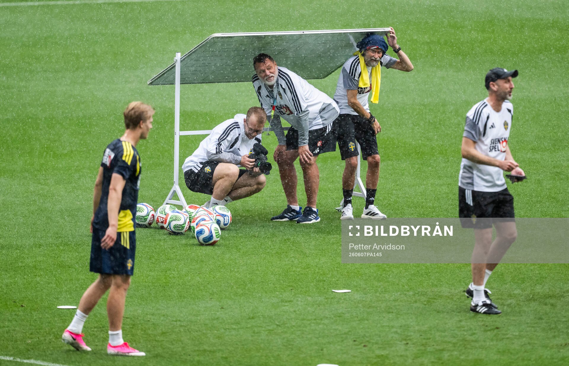 Staff hide from the rain at a training session with the