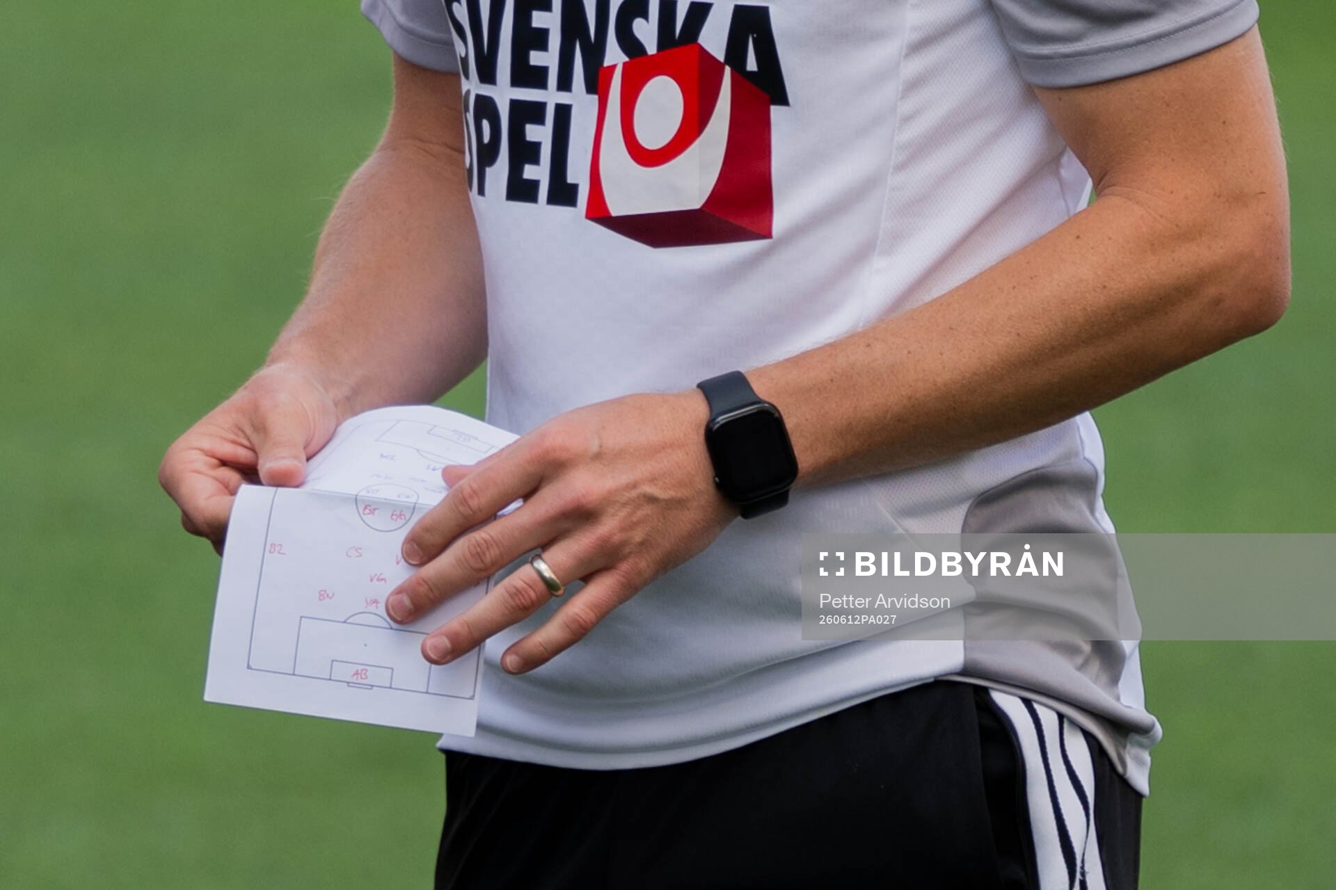 Assistant coach Sebastian Larsson with a paper at a